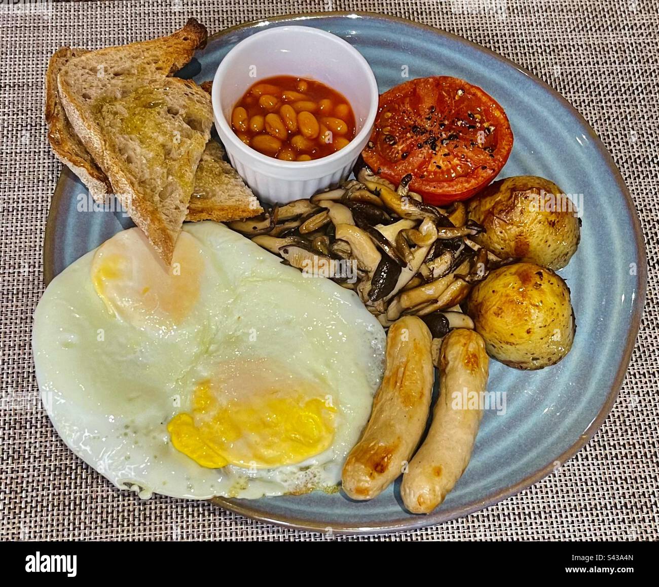 Eggs, sausage, beans potatoes and toast. Stock Photo