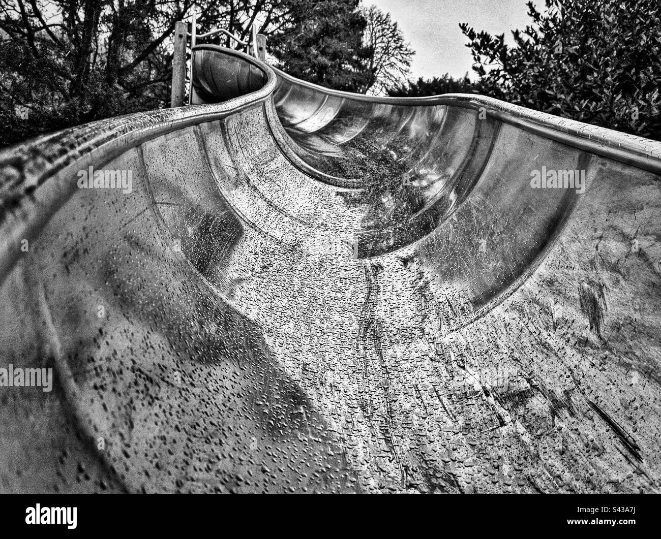 Wet slide in Cwmdonkin park Swansea Wales, black and white. - Smartphone Captured Stock Image