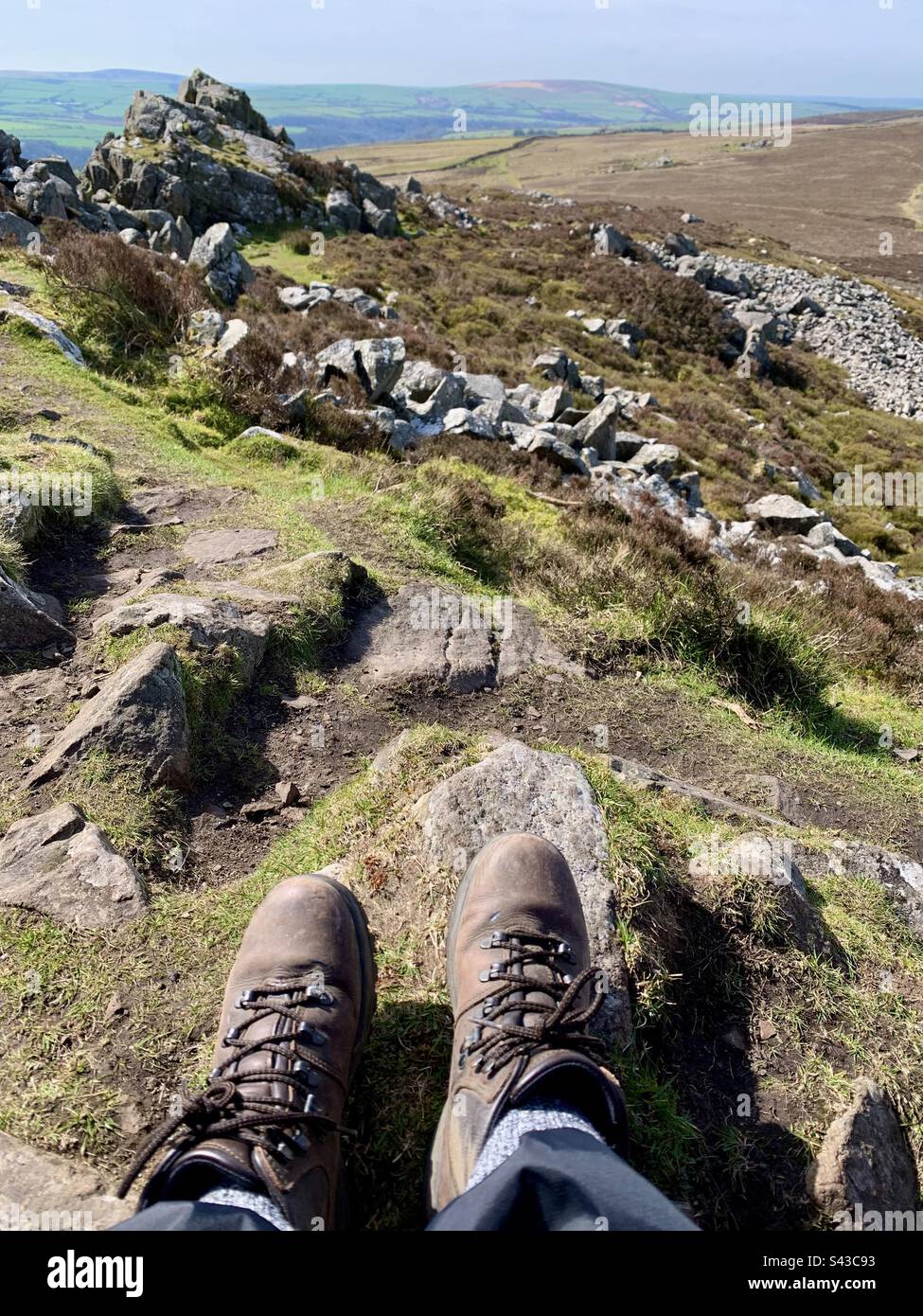 Hiking boots on feet at top of mountain with view - Smartphone Captured Stock Image