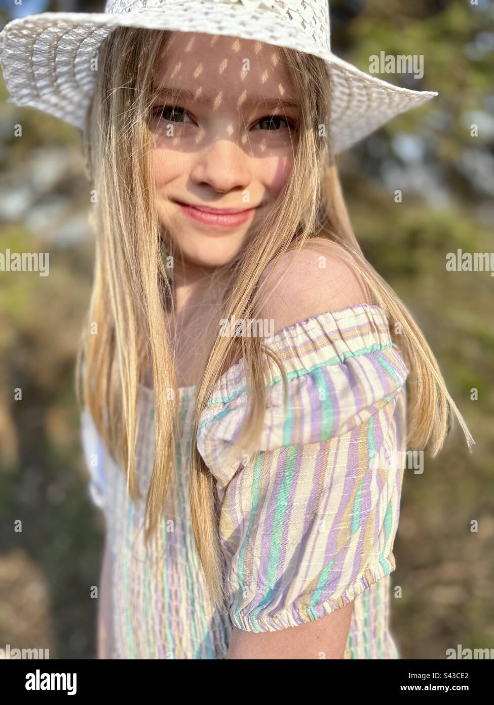 Eight year old girl smiling in the sunshine Stock Photo