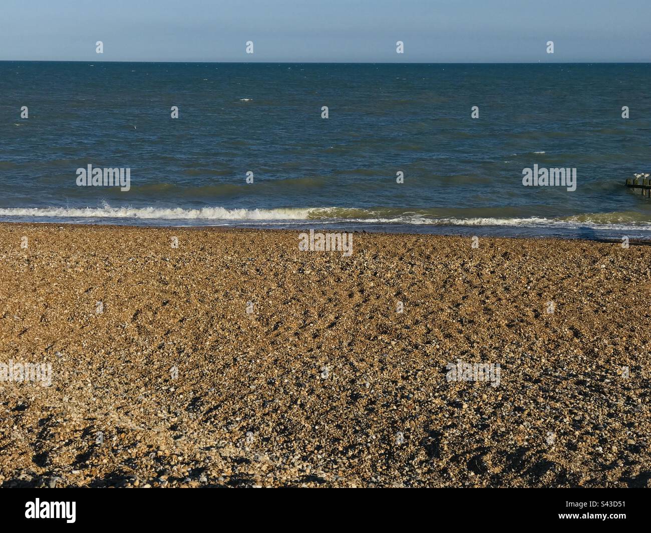 The tide, rolling on to the beach, at Pevensey Bay, Sussex Stock Photo