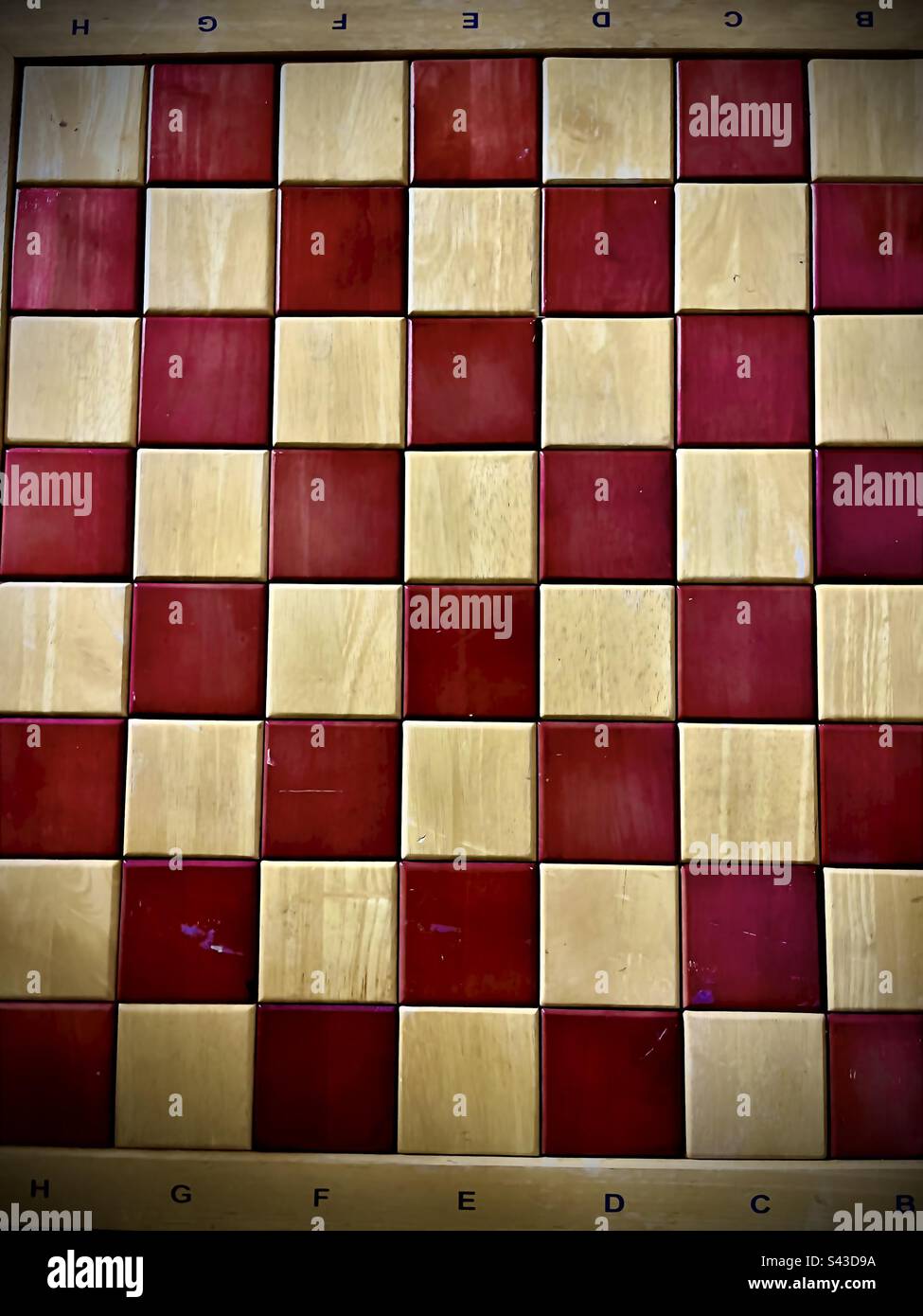 Woods chessboard with tan and brown squares, with numbers and letters at top and bottom. Fills entire frame. - Smartphone Captured Stock Image