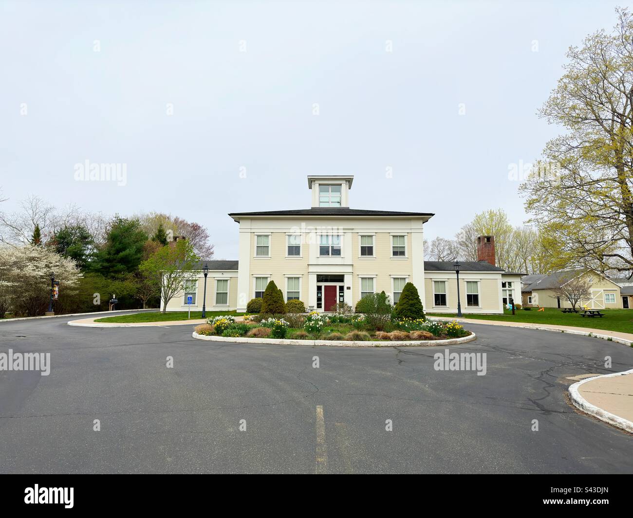 Old Lyme, Connecticut, USA:  Lyme Academy of Fine Arts section of campus with beige building, green grass, trees, and round driveway. Extension of University of New Haven. - Smartphone Captured Stock Image