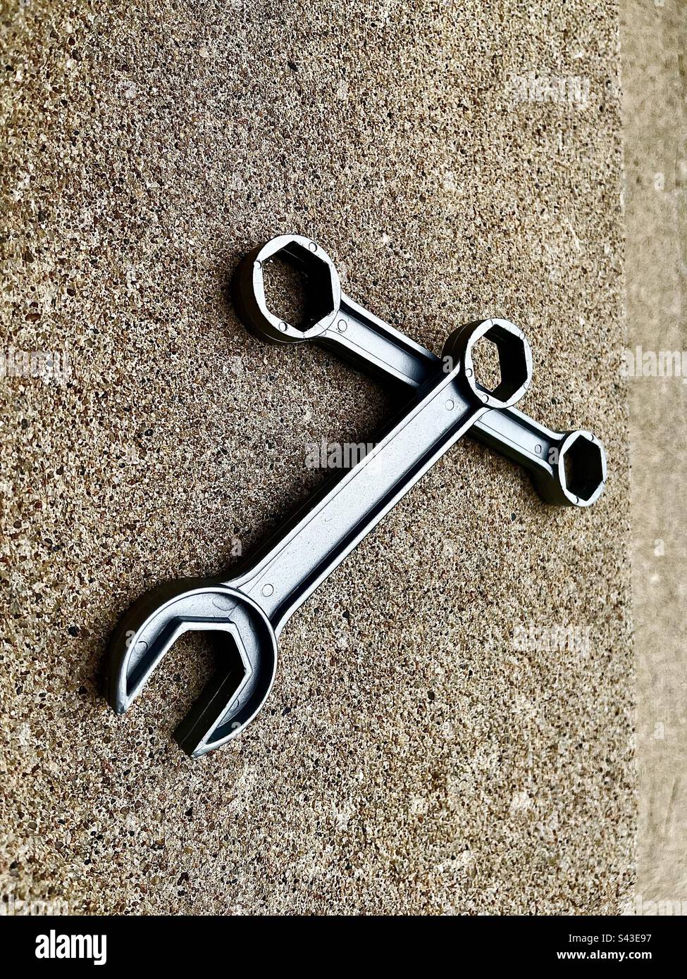 2 gray wrenches in center of frame with cement background. Includes print space. - Smartphone Captured Stock Image