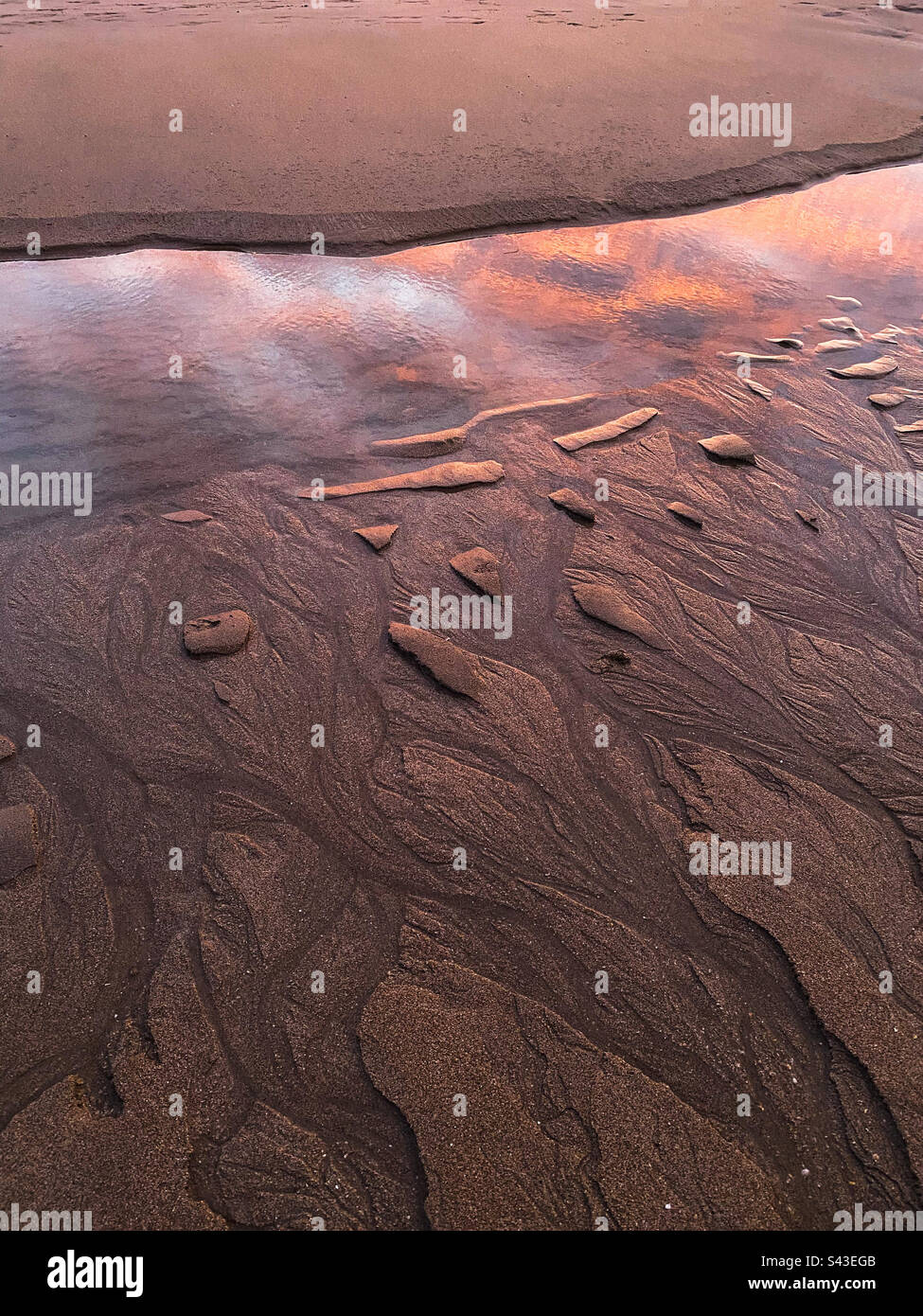 Sunset reflection on a sandy beach. - Smartphone Captured Stock Image