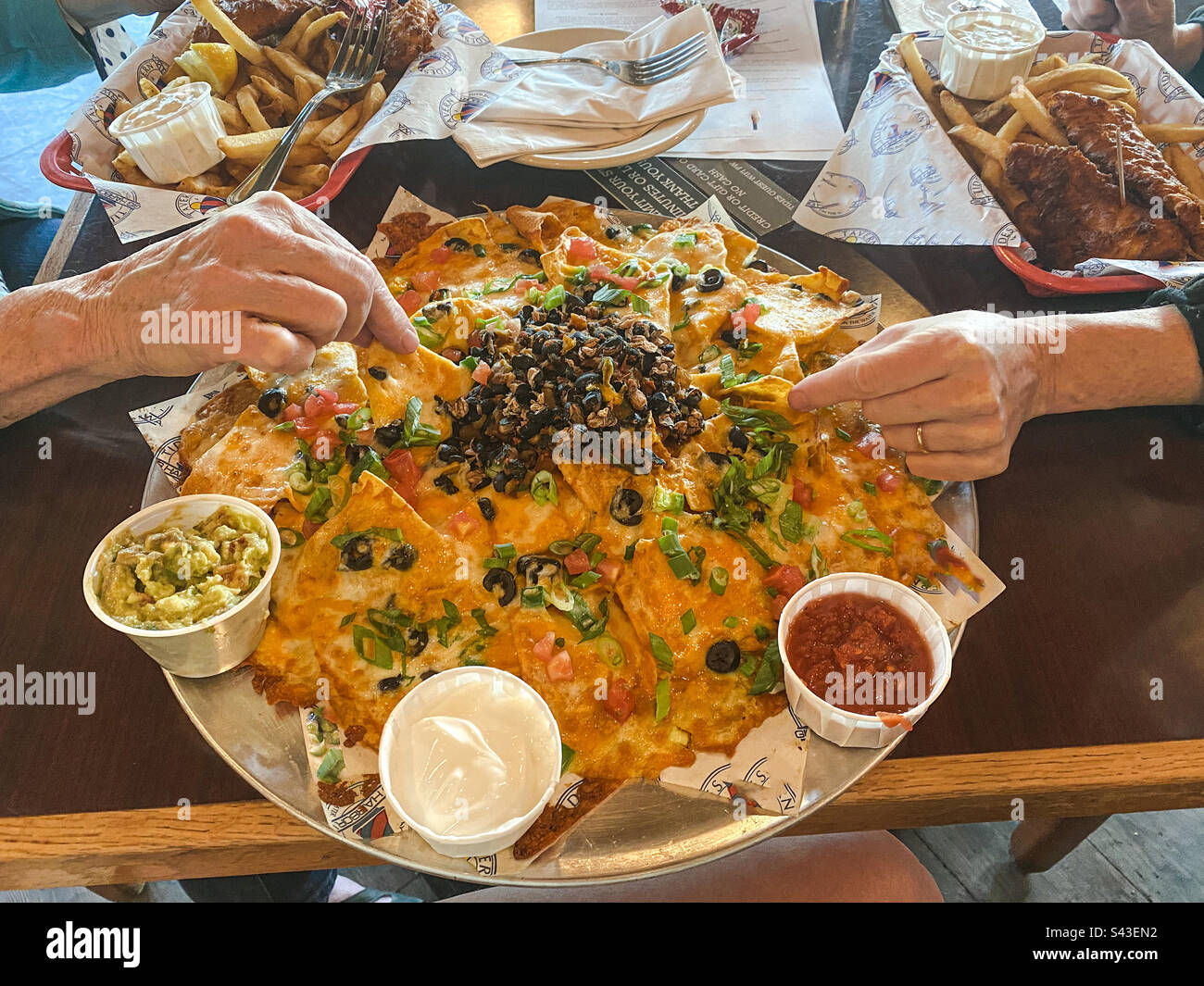 Two people sharing a giant plate of nachos. - Smartphone Captured Stock Image Two people sharing a giant plate of nachos. - Smartphone Captured Stock Image
