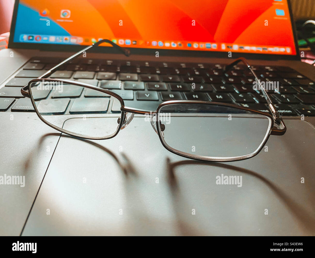 A pair of reading glasses on a laptop keyboard. - Smartphone Captured Stock Image