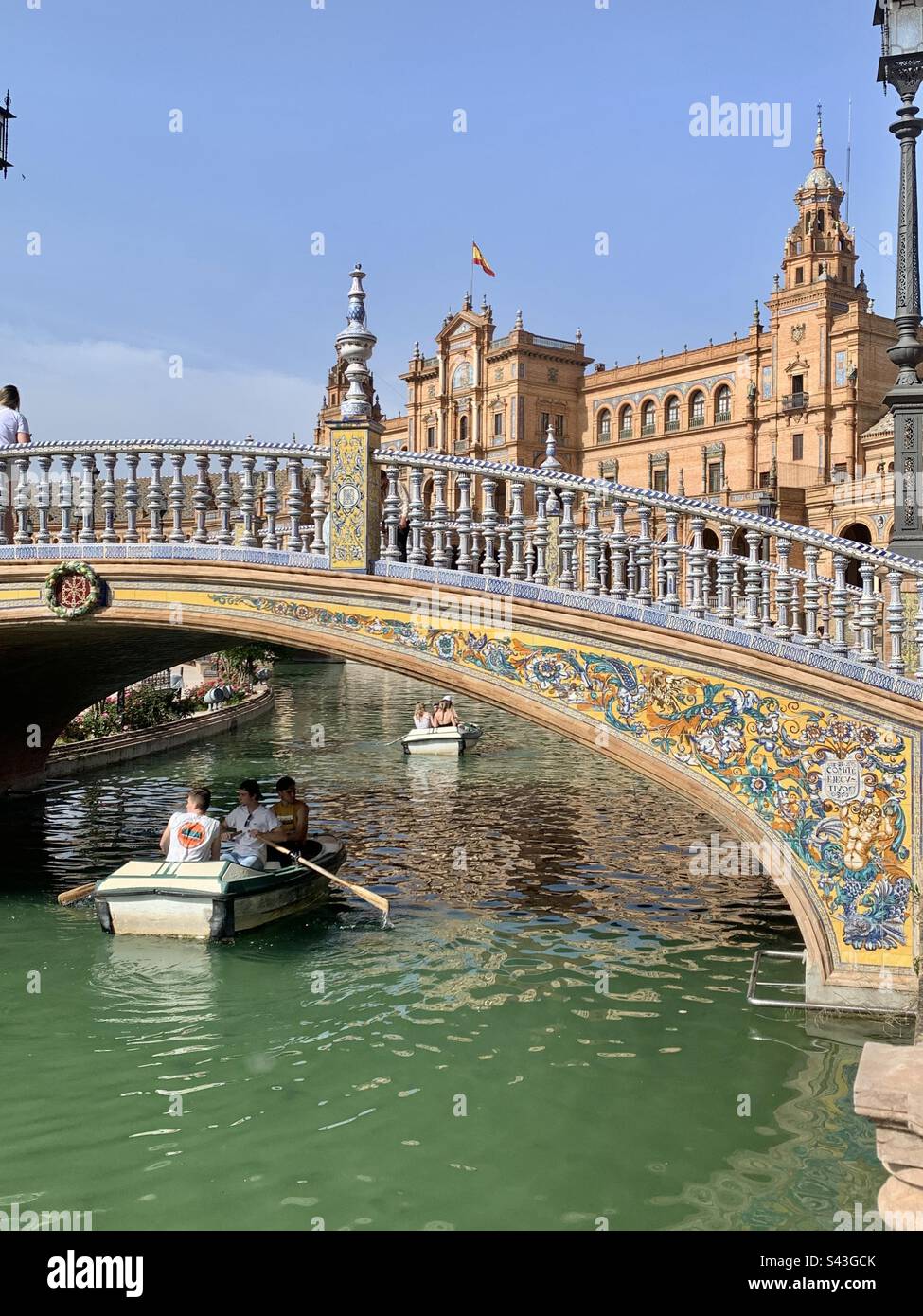 Tourists rowing a boat under the bridge at Plaza España Seville - Smartphone Captured Stock Image
