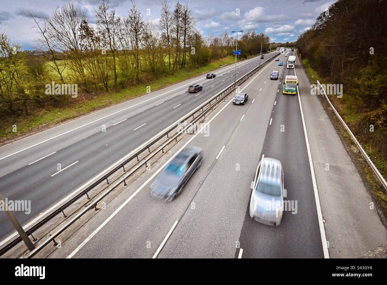 Fast moving motorway traffic passing under a bridge in the UK Stock Photo