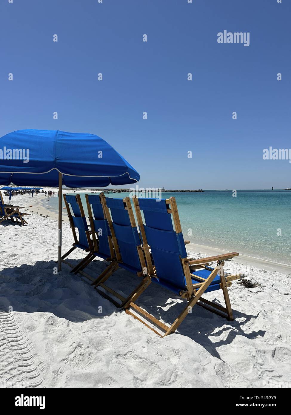 Blue beach chairs and umbrella at Destin Florida East Pass Stock Photo