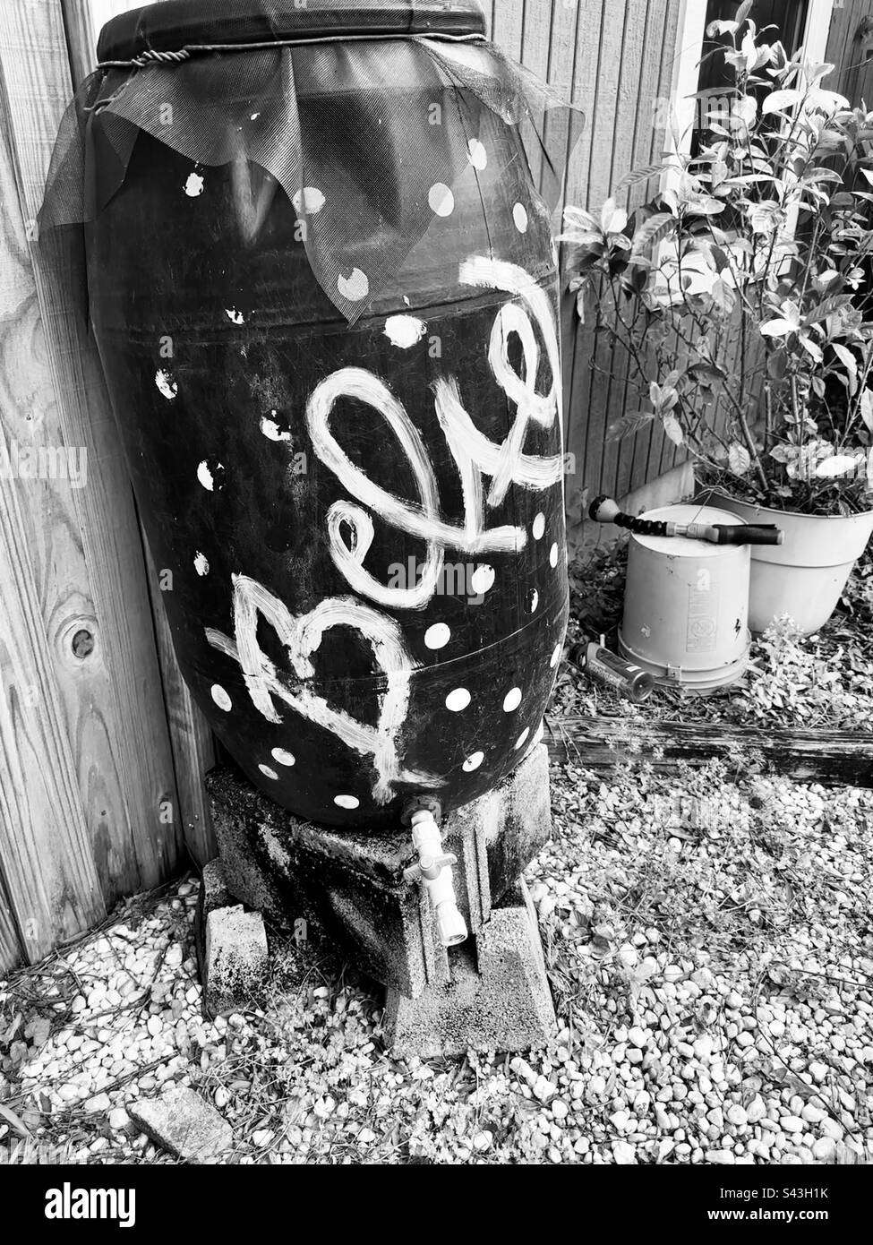 Eco friendly hand crafted rain barrel. Black and white photo . Believe