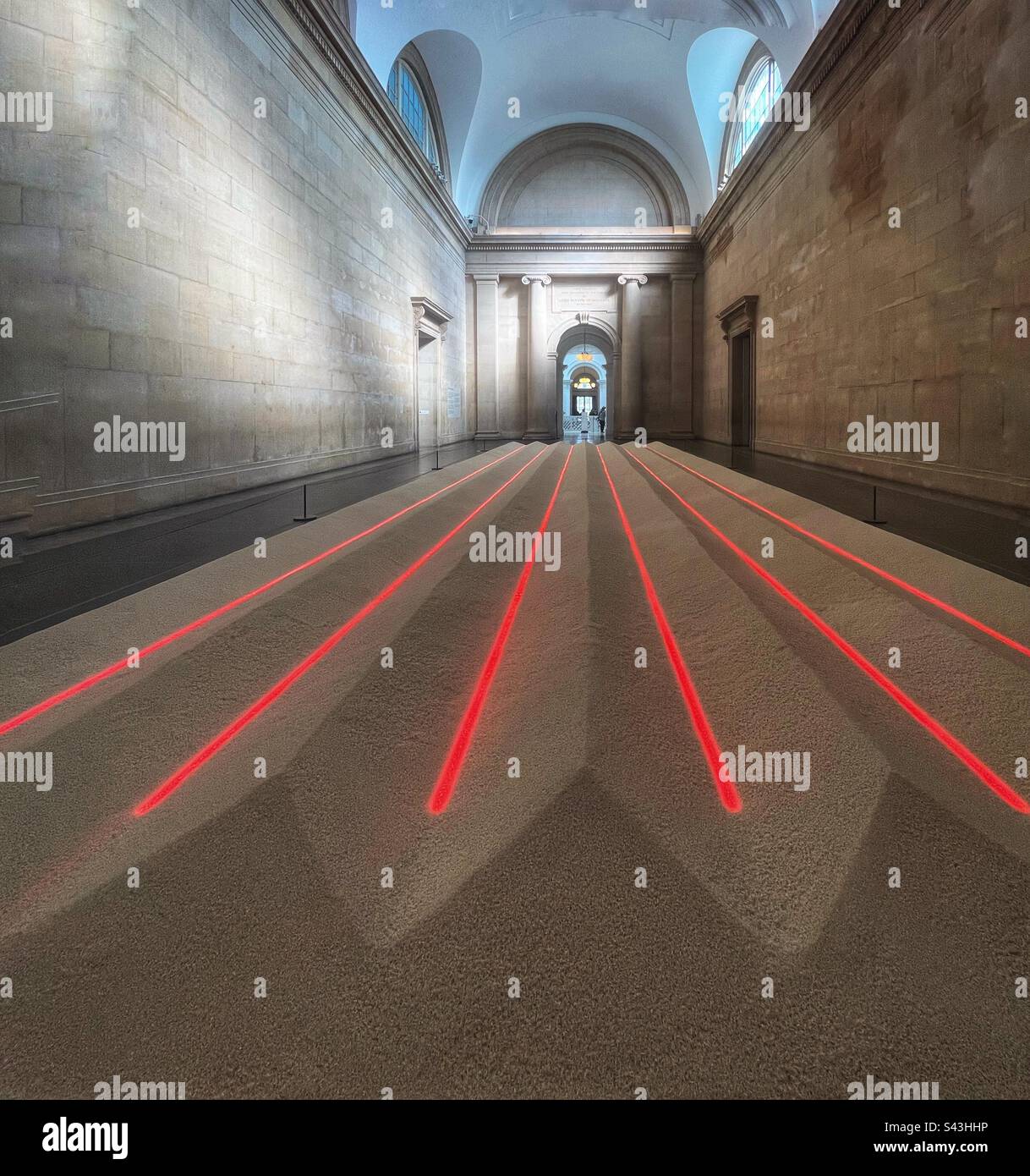 Neon Rice Field (1993) is a large floor based installation consisting of seven tons of dry, white grain rice underlaid at intervals with six parallel tubes of red neon light. By Vong Phaophanit, Tate - Smartphone Captured Stock Image