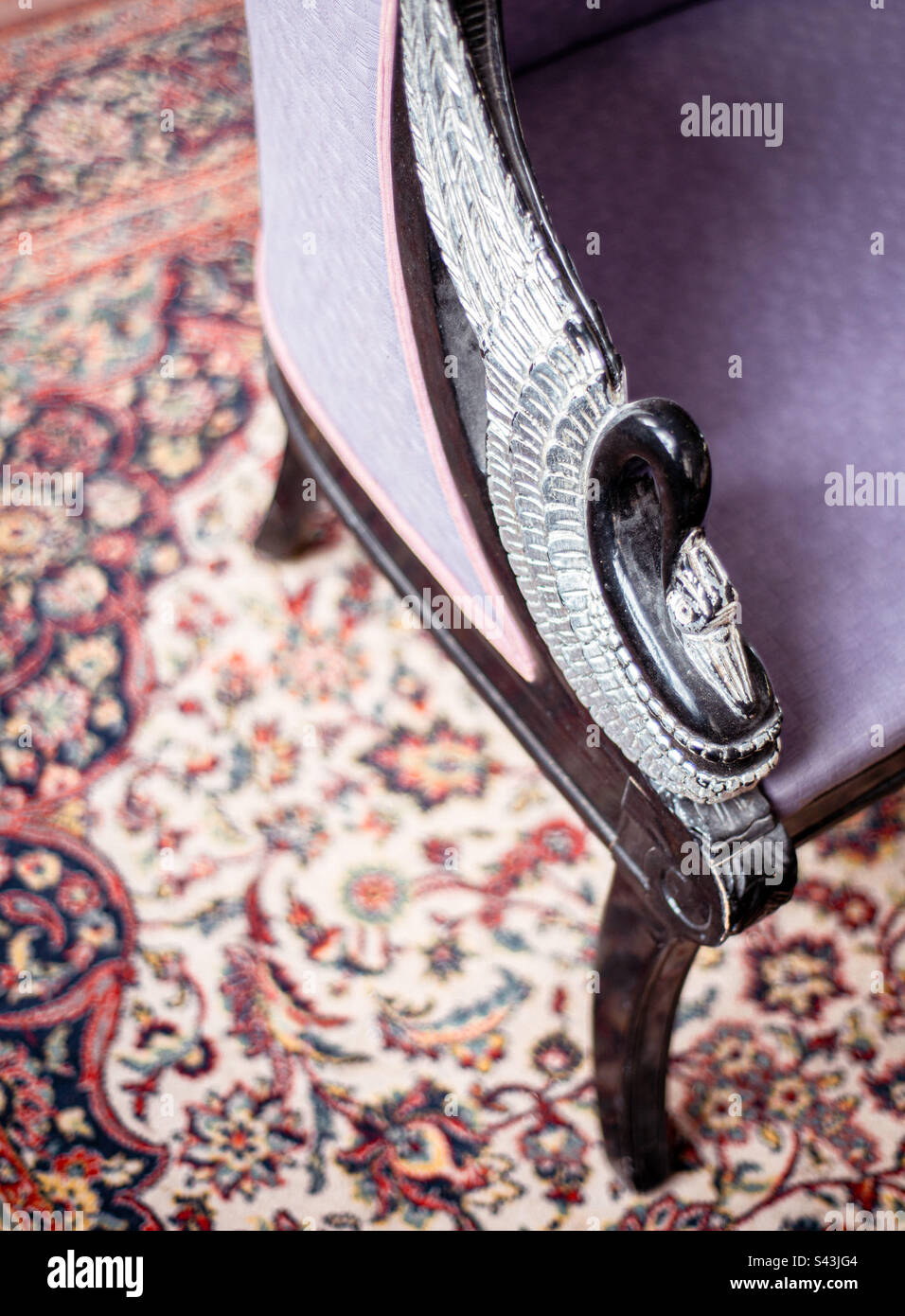 Antique purple couch, with a beautifully carved bird design on the arm - Smartphone Captured Stock Image
