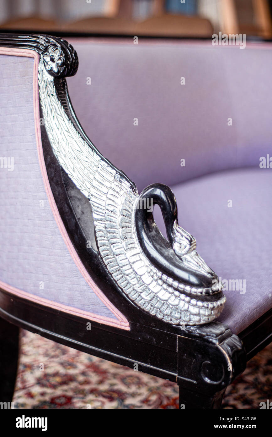 Antique purple love seat, with a beautifully carved wooden bird, designed into the arm rest - Smartphone Captured Stock Image