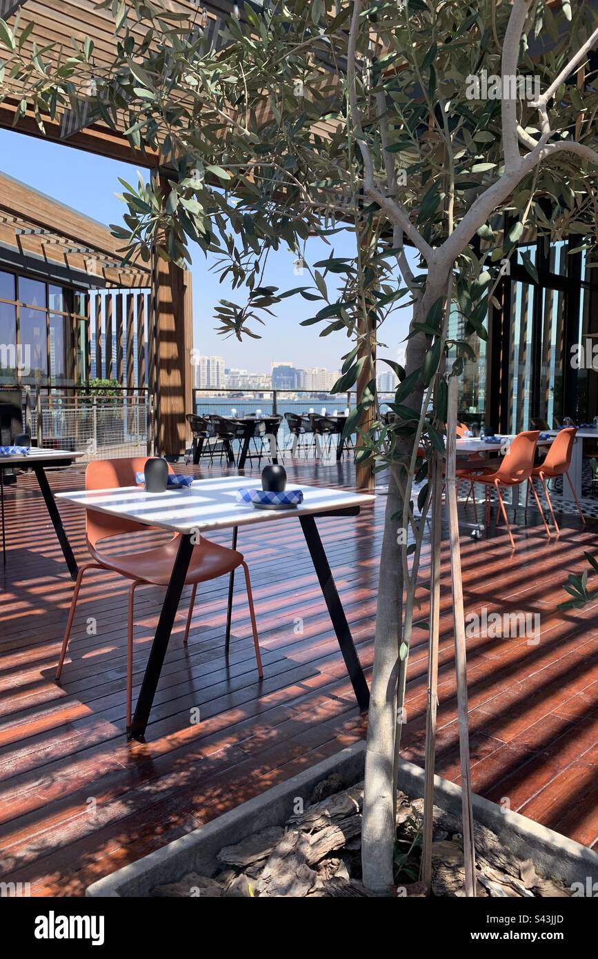 Outdoor restaurant terrace with a view over the Dubai Creek in Dubai, United Arab Emirates - Smartphone Captured Stock Image