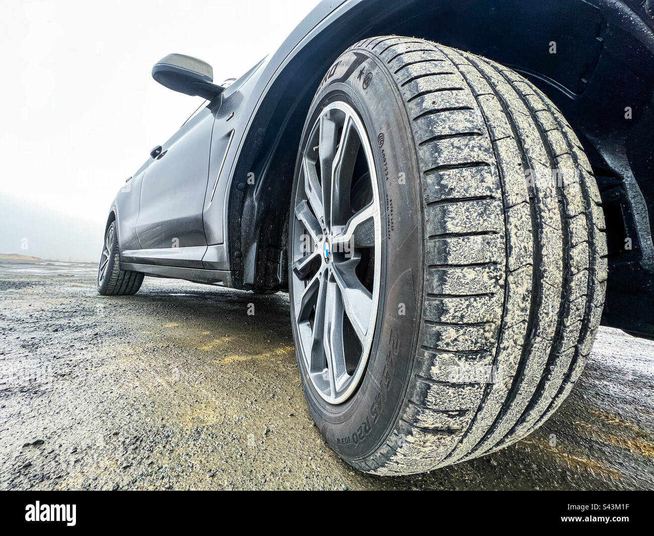 BMW wheel with mud on tyre - Smartphone Captured Stock Image