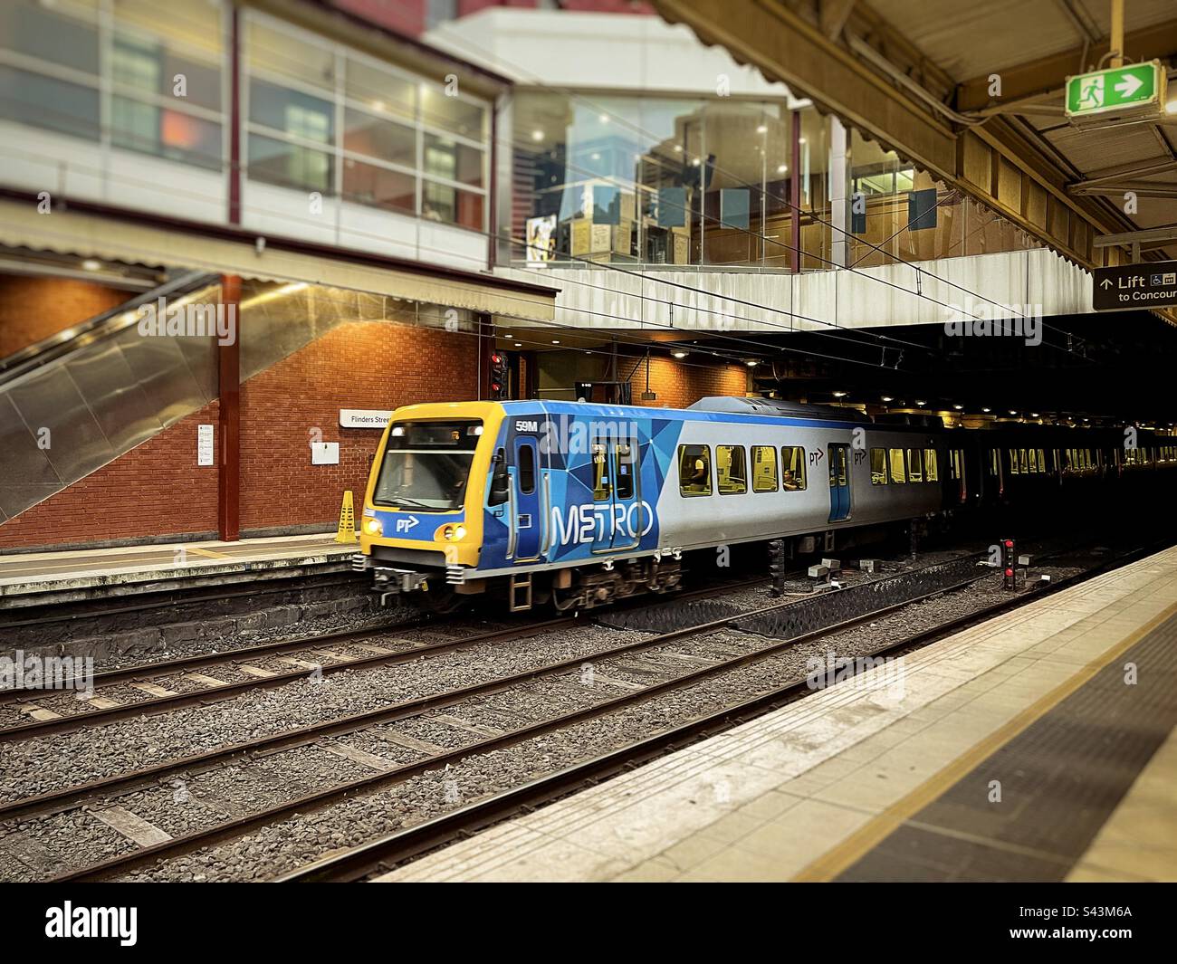 Metro train arriving at railway station platform in Flinders Street Railway Station in Melbourne, Victoria, Australia. First city railway station in Australia. - Smartphone Captured Stock Image