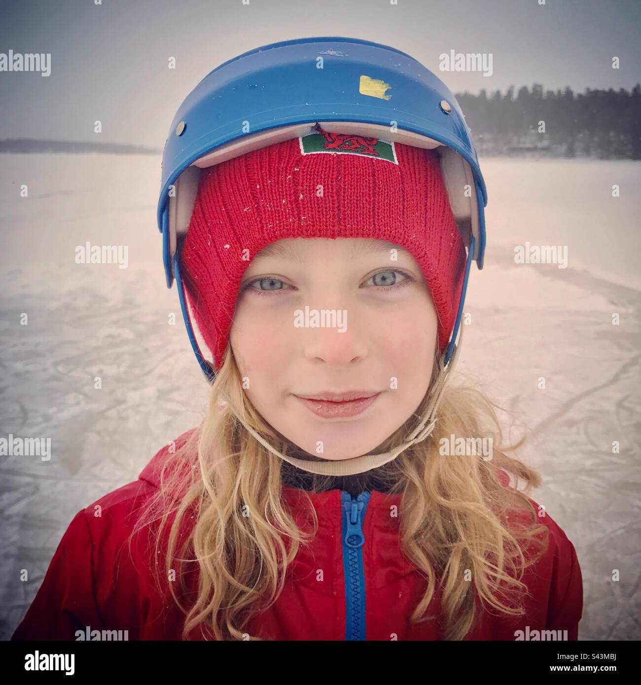 A portrait of a young 10 year old girl in a helmet ice skating on a lake in deep winter in Scandinavia Stock Photo Alamy