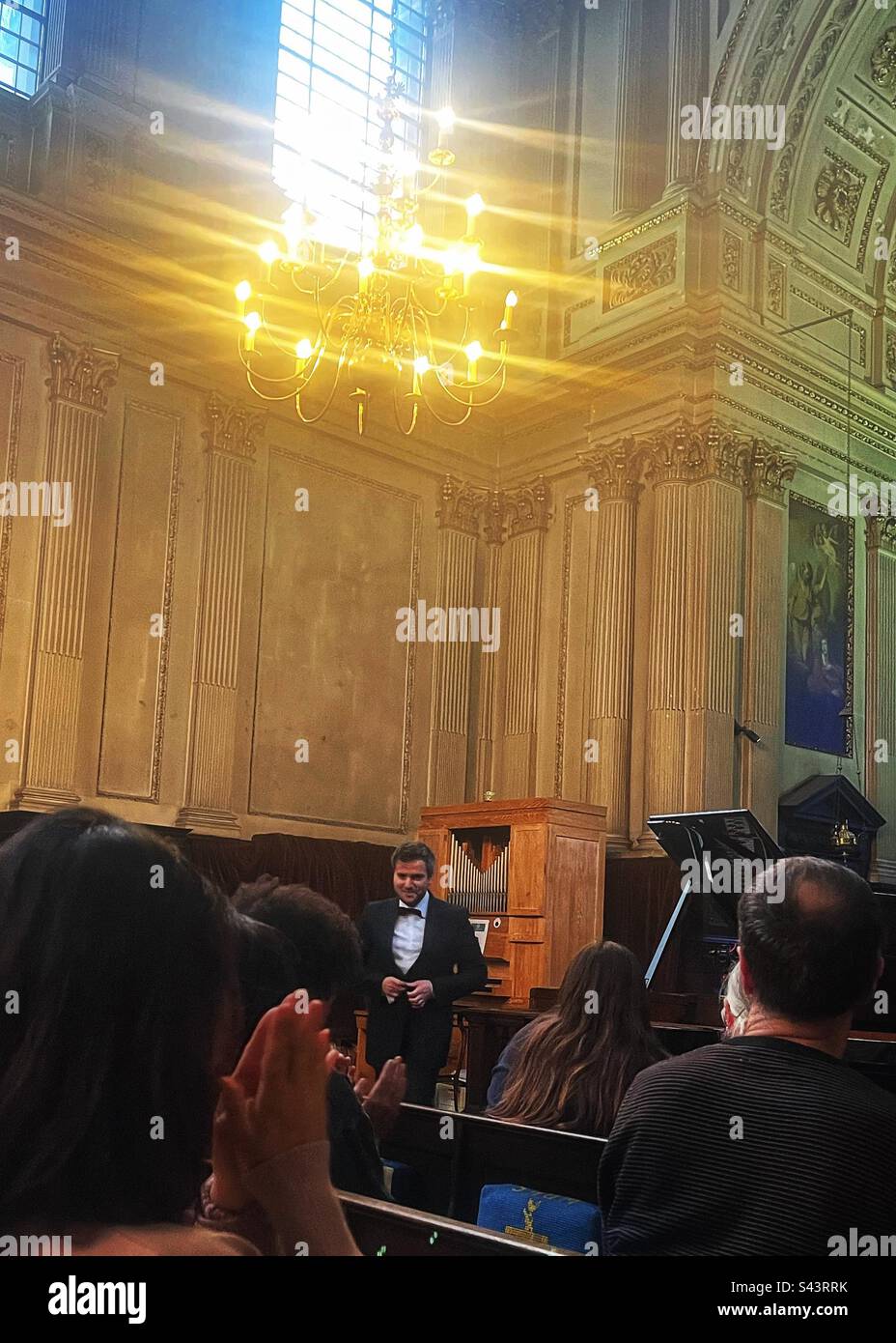 Pianist Florian Mitrea takes the applause at a recital held at St Mary Le Strand Church in London. He is professor at the Royal Academy of Music in London too. - Smartphone Captured Stock Image
