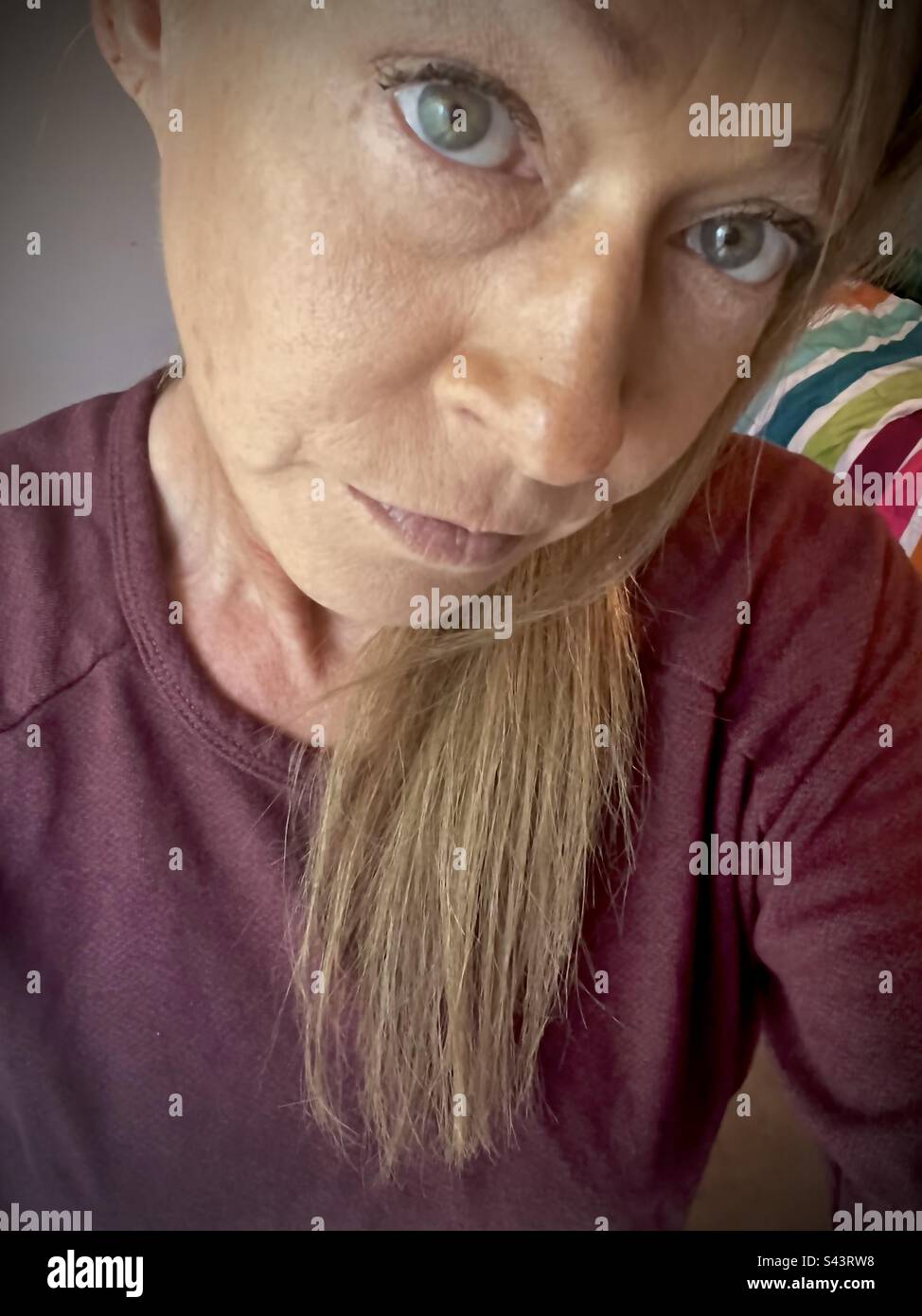 Middle aged woman in burgundy sweatshirt - Smartphone Captured Stock Image