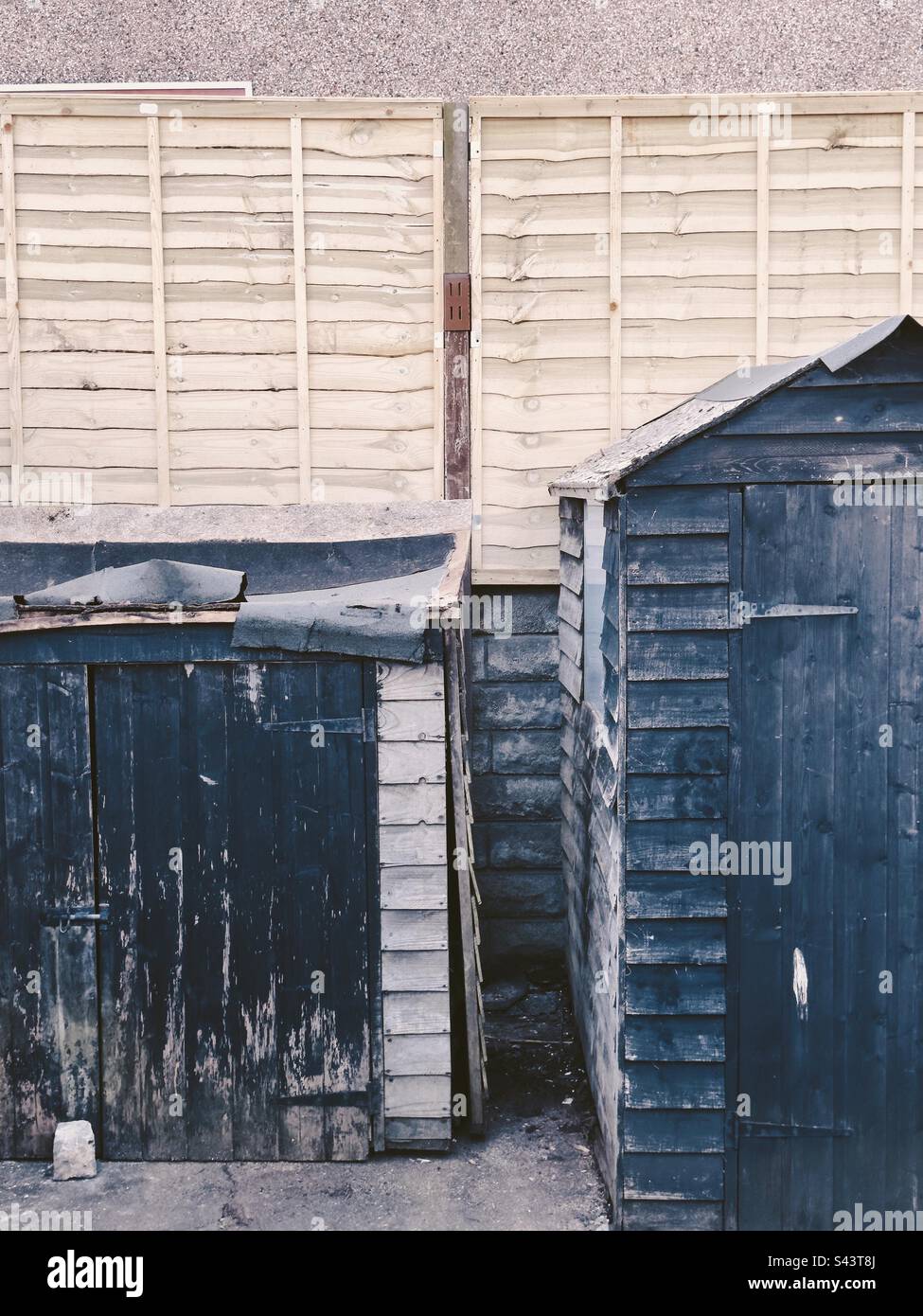 Two Rickety sheds in need of repair at the bottom of a garden. - Smartphone Captured Stock Image