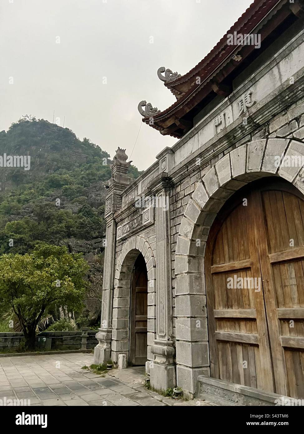 Ancient monument in Asia with foggy mountains and large wooden gate Stock Photo