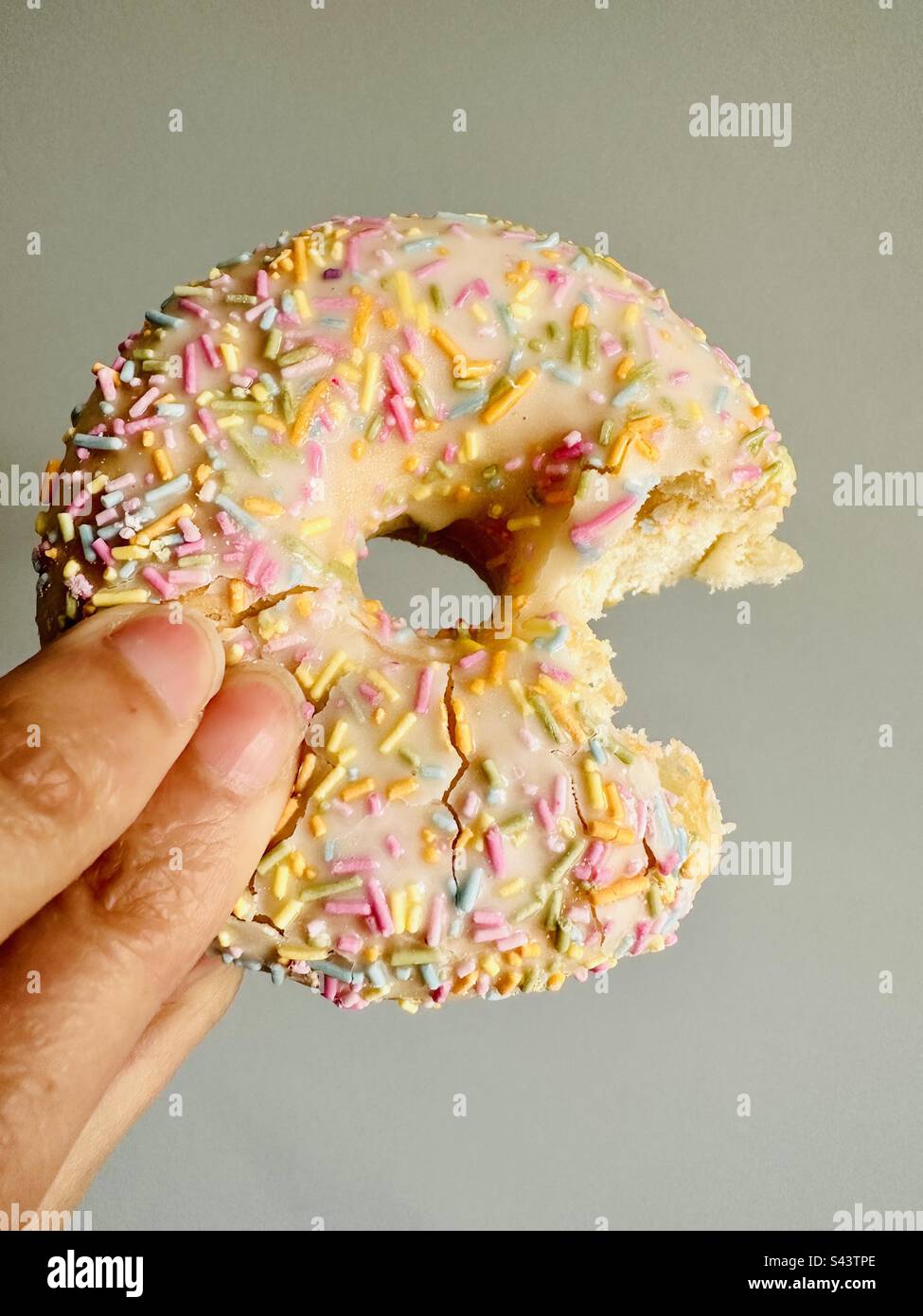 Donut with sugar strand sprinkles on top with a bite taken out - Smartphone Captured Stock Image