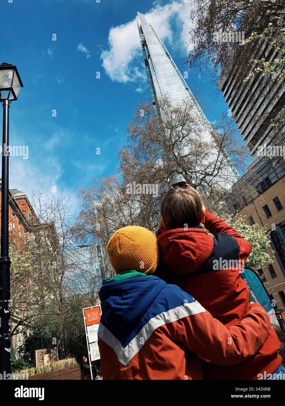 Two children taking a picture of the Shard in London with a smartphone - Smartphone Captured Stock Image