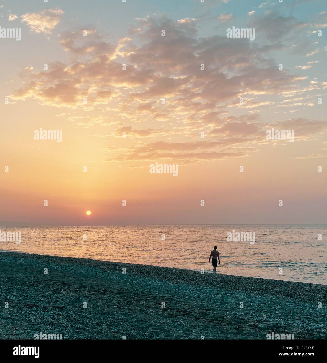 Person walking alone at sunset on the beach. - Smartphone Captured Stock Image