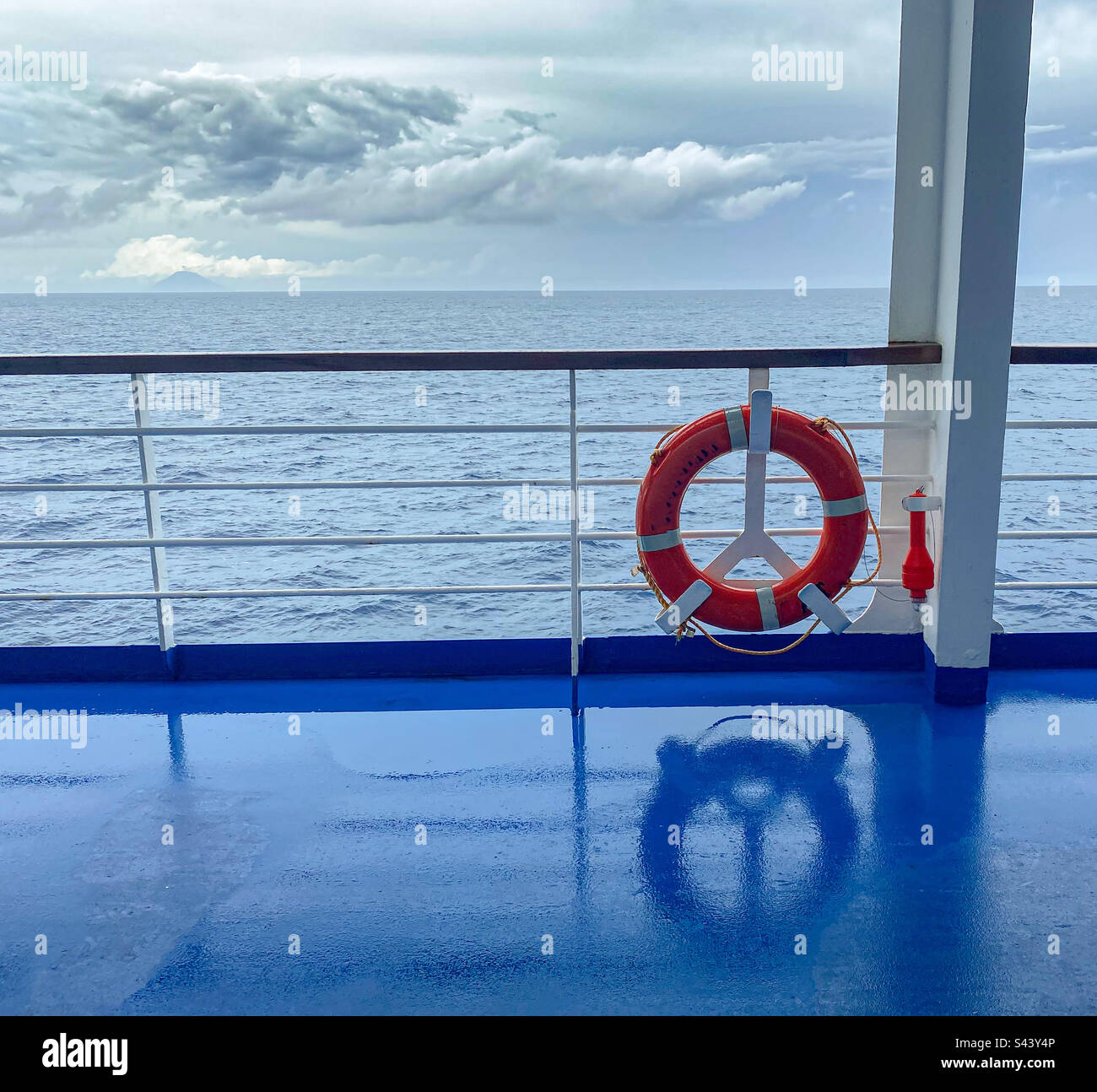 Bright orange life ring against a story sea. - Smartphone Captured Stock Image