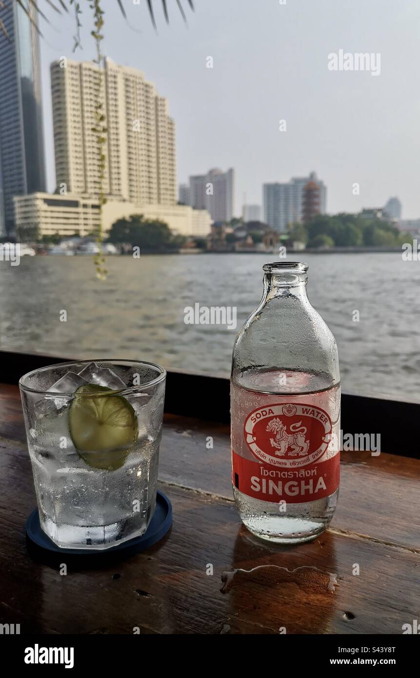 Drinking a bottle of Singha soda water by the Chao Phraya river in Bangkok,  Thailand Stock Photo - Alamy