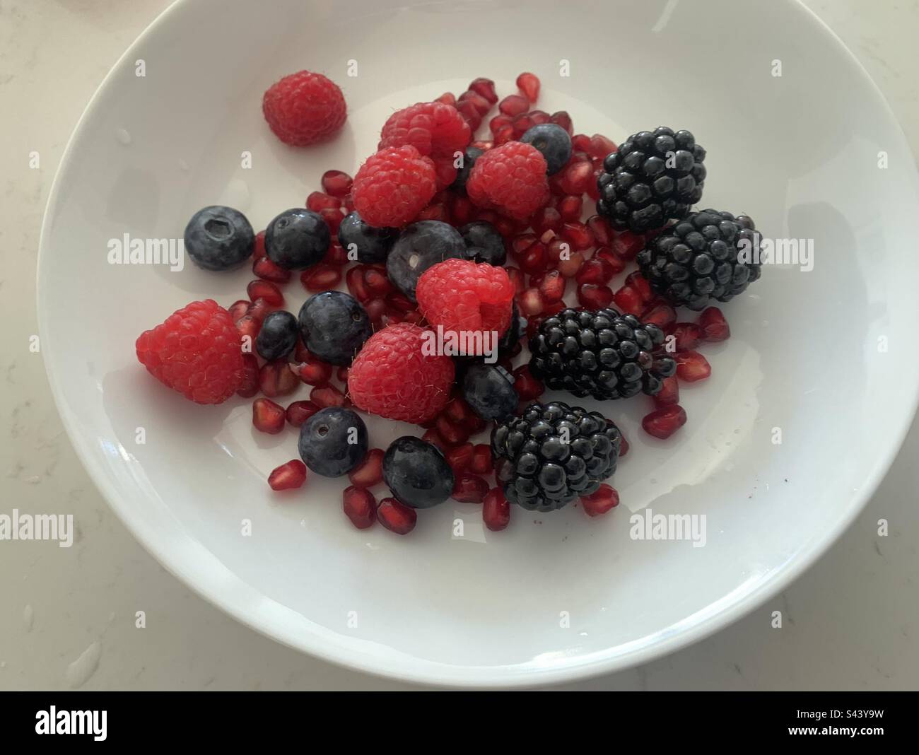 Closeup image of a bowl of mixed berries and pomegranate - Smartphone Captured Stock Image
