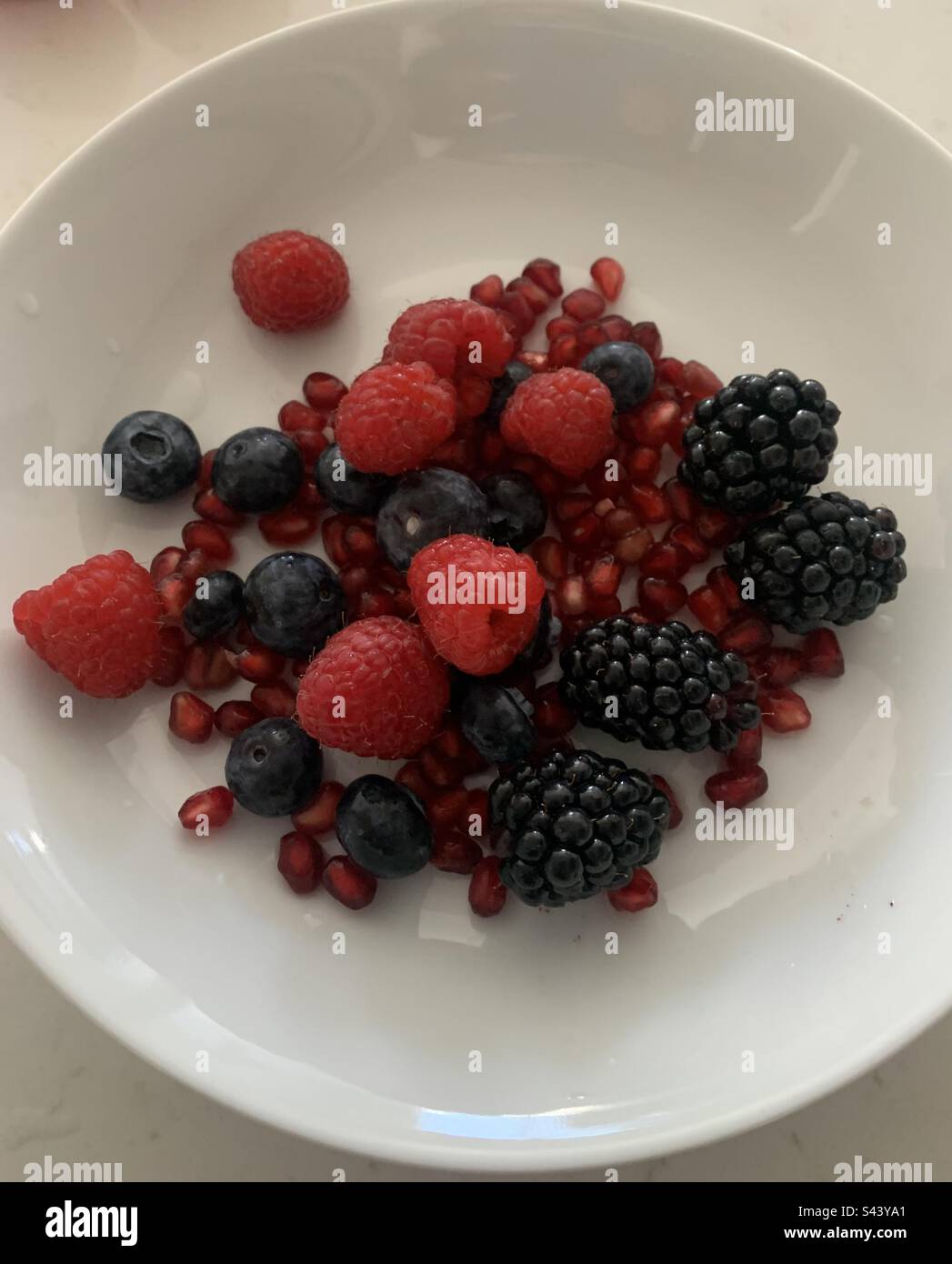 Closeup image of a bowl of mixed berries and pomegranate - Smartphone Captured Stock Image