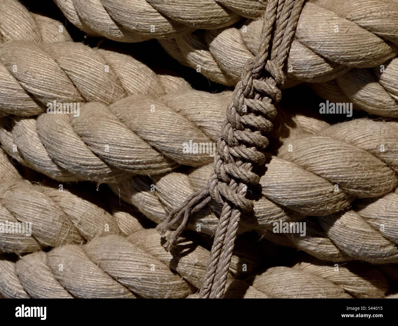 A massively thick rope or hawser tied with a knotted cord on display in the French ropery museum in Rochefort - Smartphone Captured Stock Image