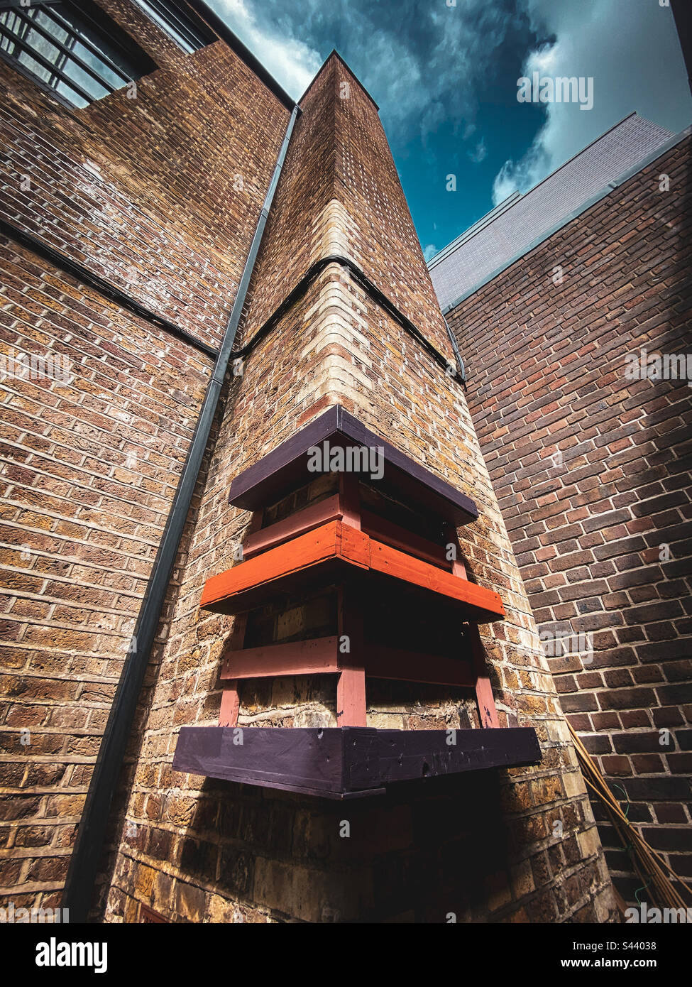 Colourful pallets used as planters on a brick wall - Smartphone Captured Stock Image