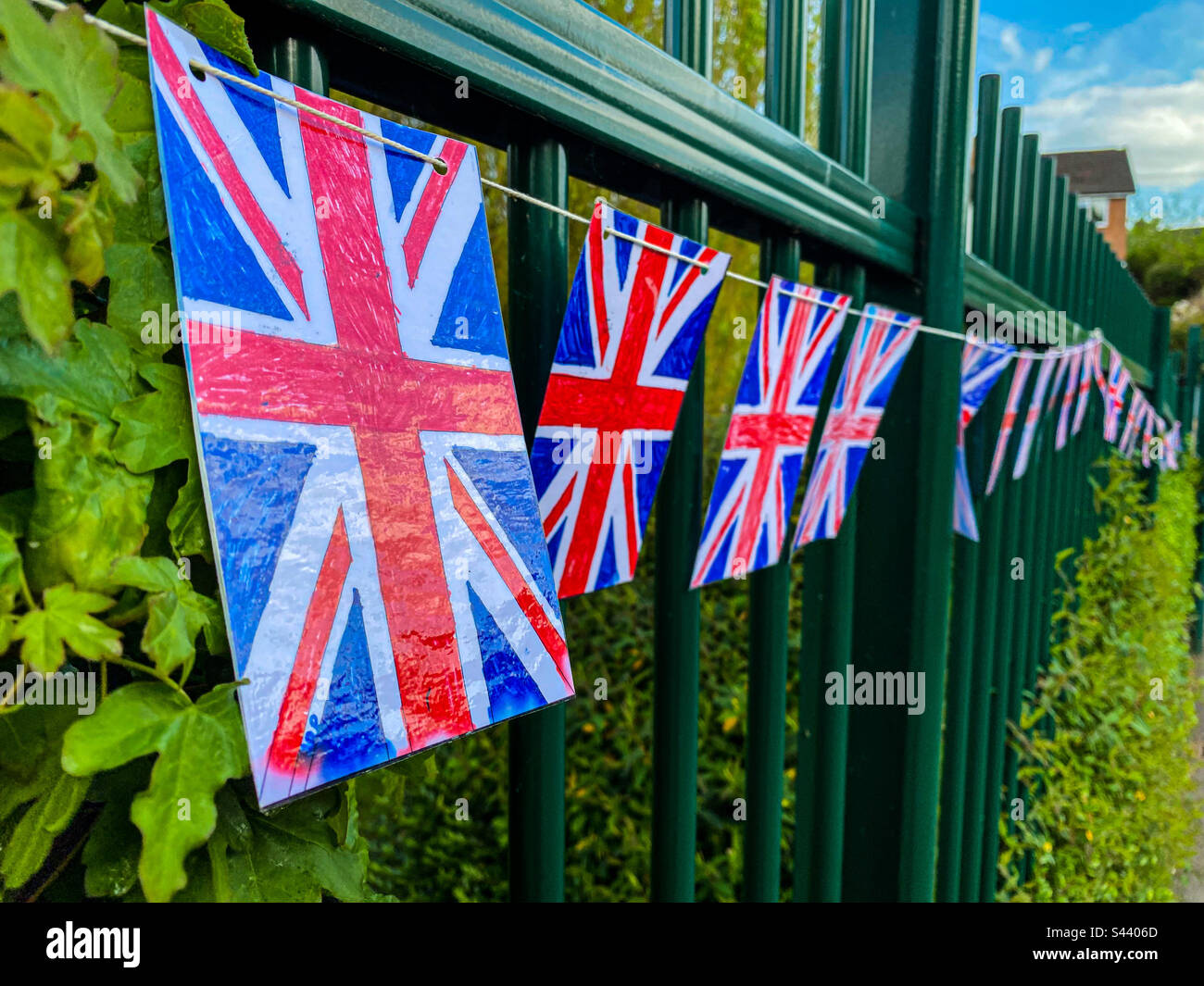 Red, white and blue Union Jack bunting hanging from a fence. - Smartphone Captured Stock Image