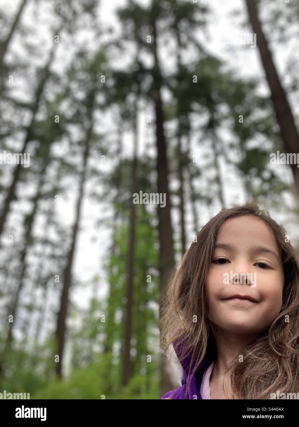 Little girl liking at camera in woods Stock Photo Alamy