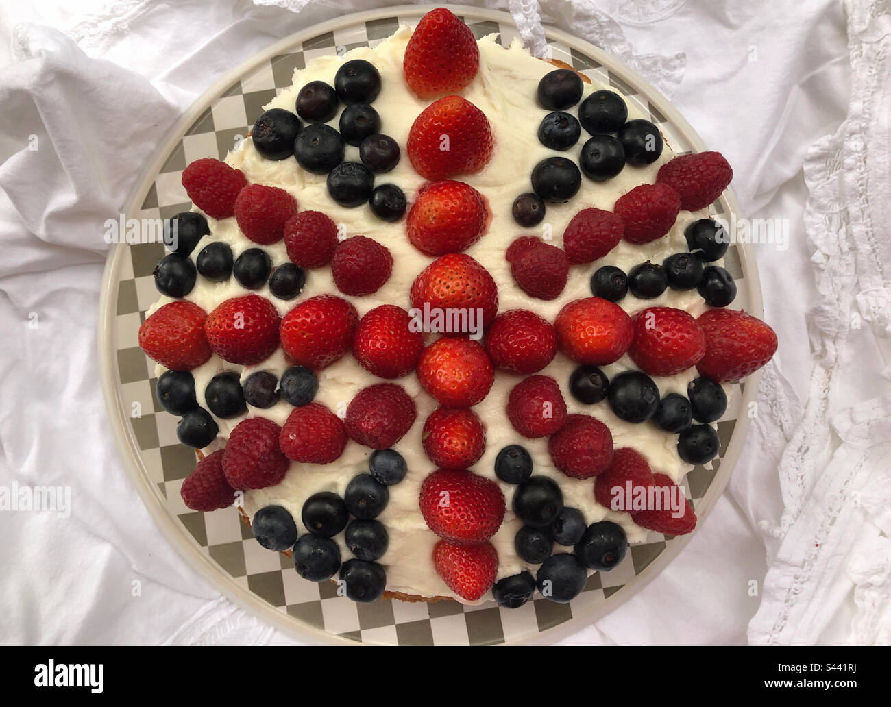A Victoria sponge with fresh berries creating the Union Jack made for Coronation Day. - Smartphone Captured Stock Image