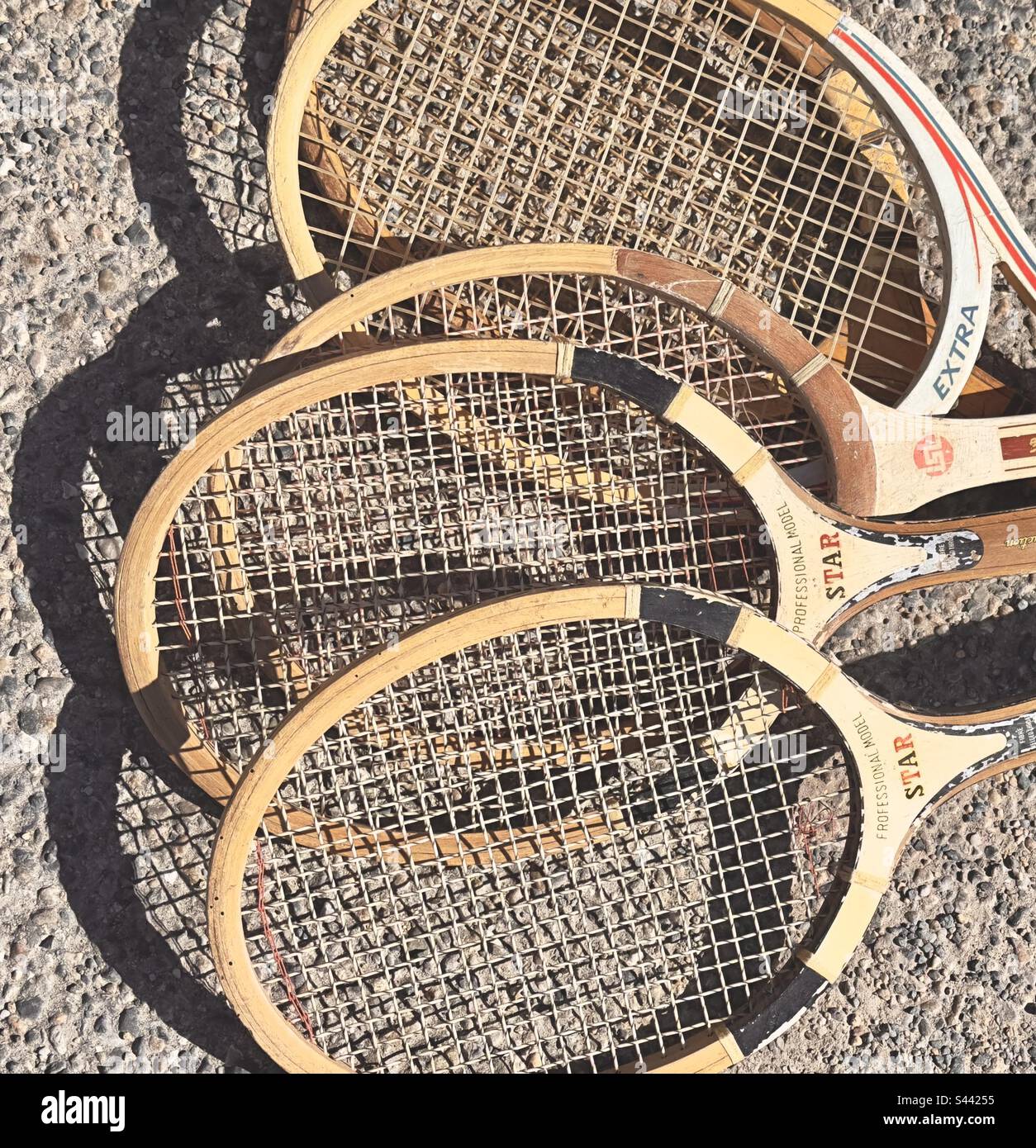 A collection of old wooden tennis raquets for sale in a French fleamarket. - Smartphone Captured Stock Image