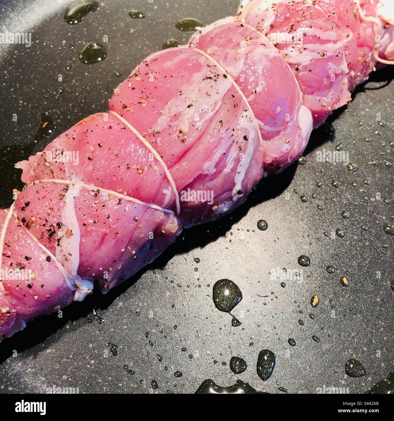 View of a pork filet in a fry pan - food preparation - Smartphone Captured Stock Image