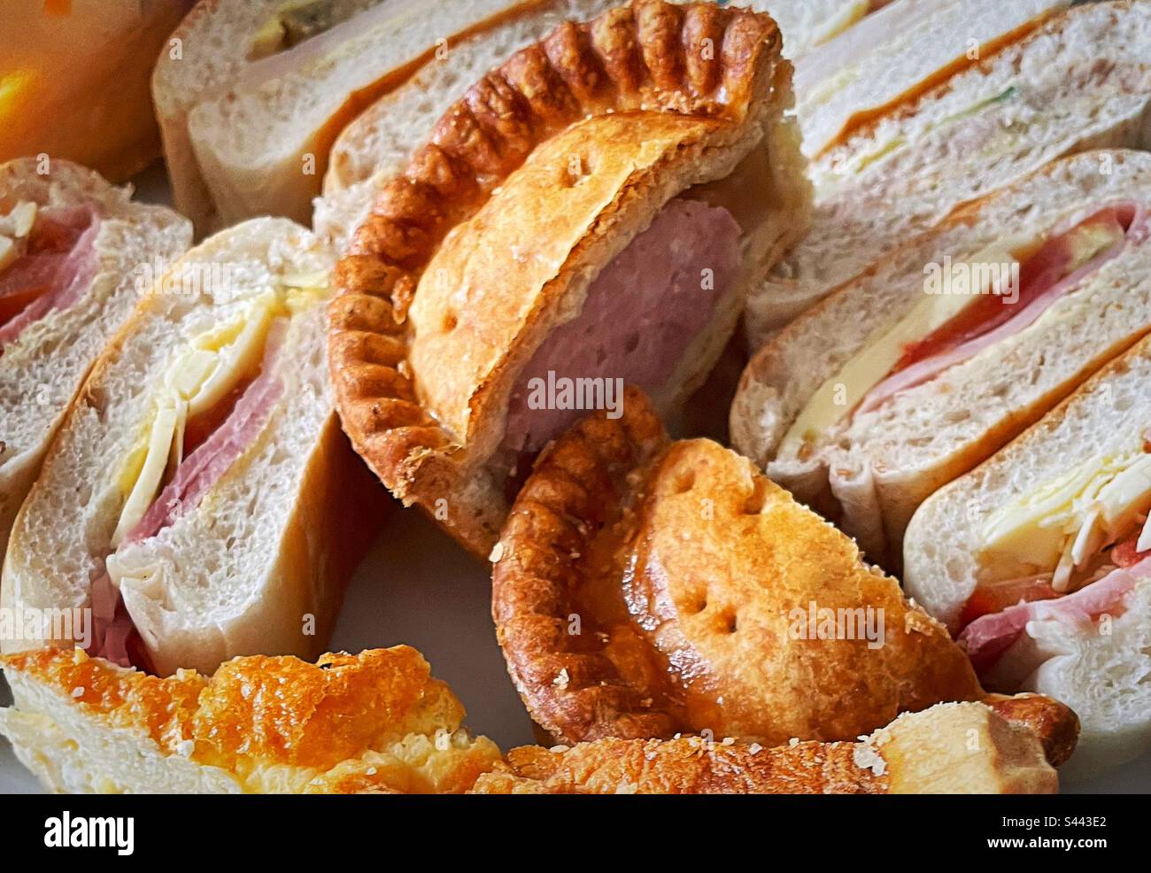 ‘Pork pie picnic’ a typically British picnic. Sandwiches, pork pie and quiche. Stock Photo