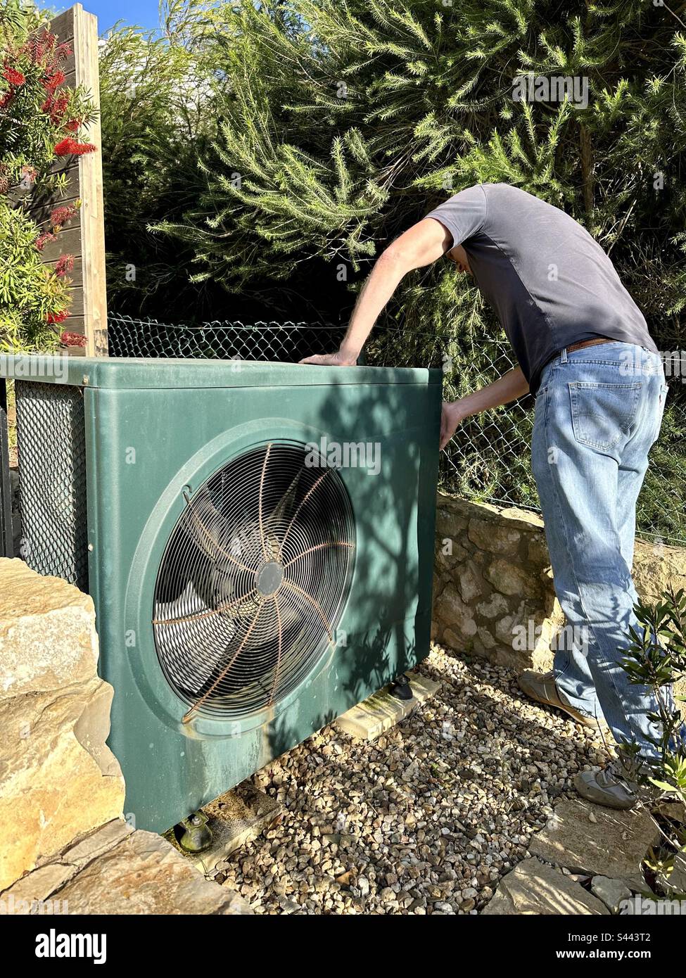 Man inspecting an electric swimming pool heater - Smartphone Captured Stock Image