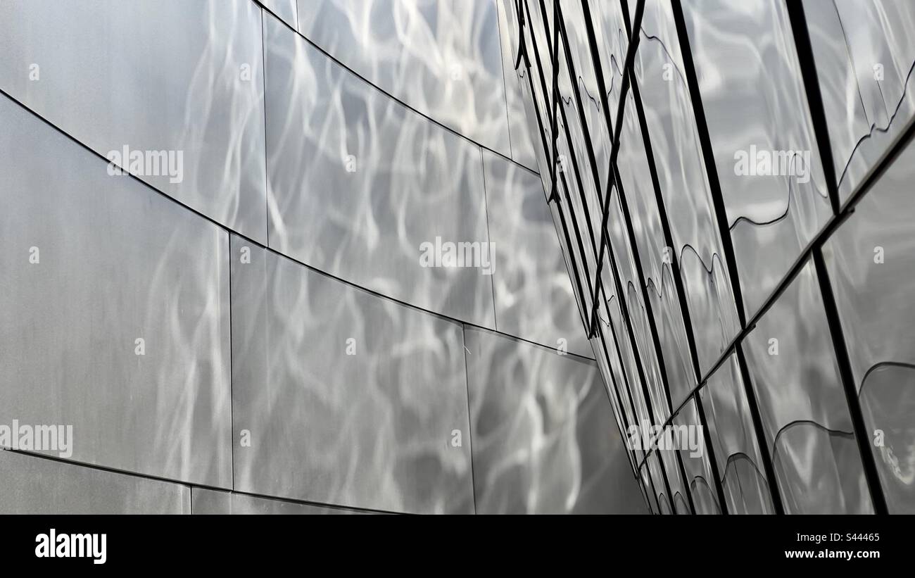 Wide view with deep focus, sunlight creates rippling reflections on stainless steel walls. Abstract texture suitable for graphics backgrounds and wallpapers - Smartphone Captured Stock Image Wide view with deep focus, sunlight creates rippling reflections on stainless steel walls. Abstract texture suitable for graphics backgrounds and wallpapers - Smartphone Captured Stock Image