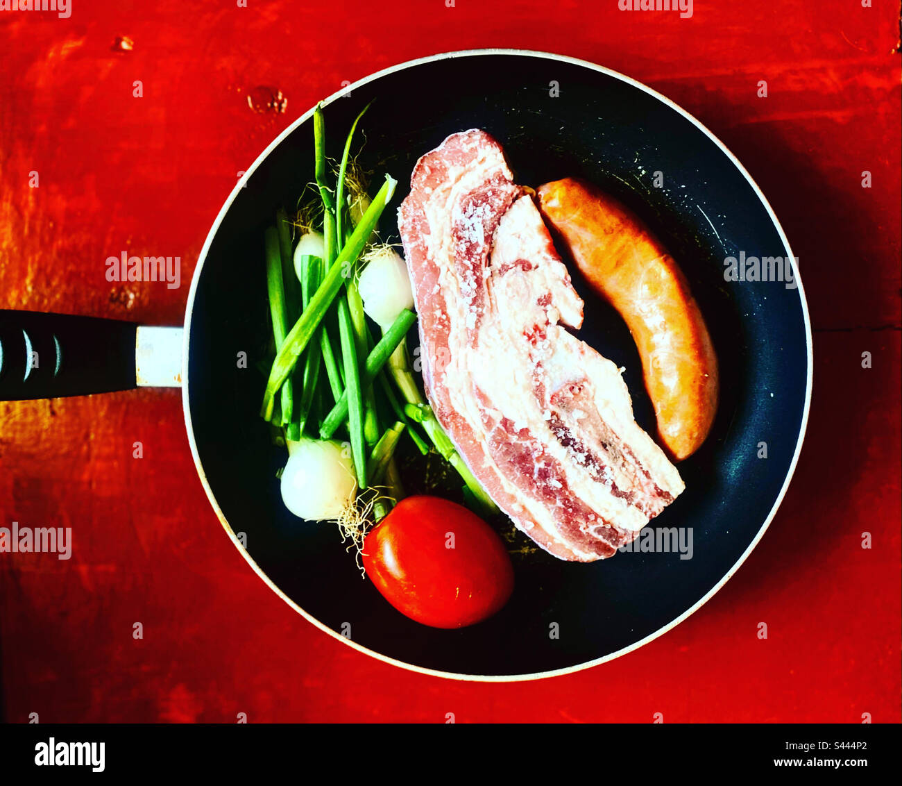 Spanish chorizo sausage, beef meat, onion and a red tomatoe ready to be grilled in Querétaro, México - Smartphone Captured Stock Image