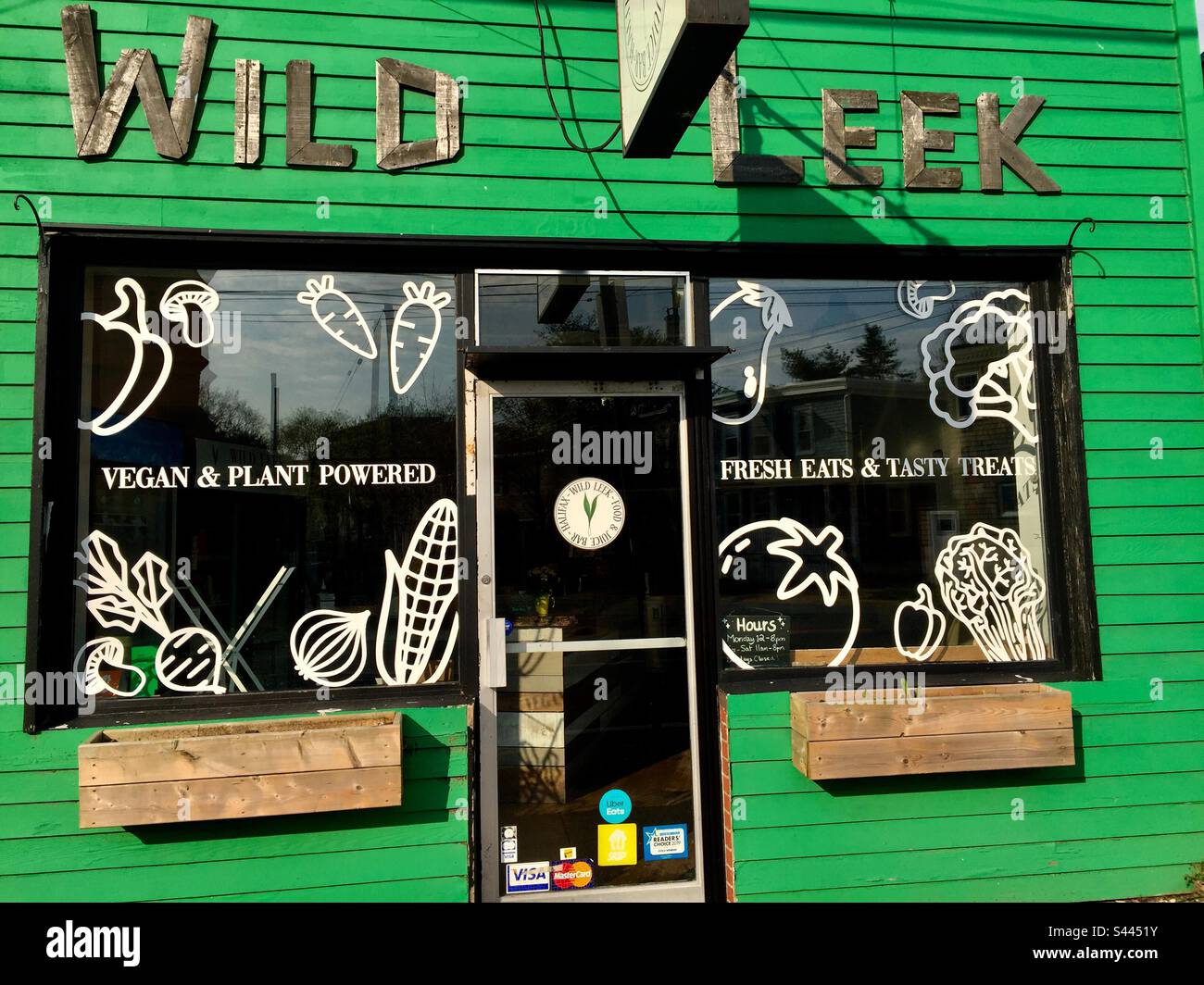 Green and good. Images and words on a storefront, Halifax, Canada. Plant powered with love. - Smartphone Captured Stock Image