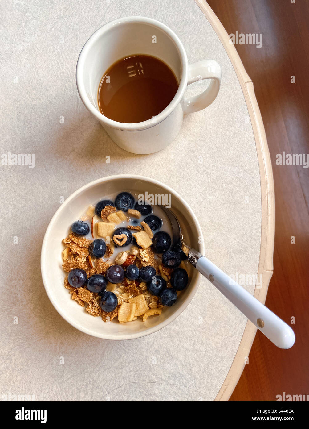 Healthy gluten free out flakes and shapes in a cereal bowl with  blueberries and nuts, almond milk and a heart shape on a blueberry. Authentic serendipity. - Smartphone Captured Stock Image