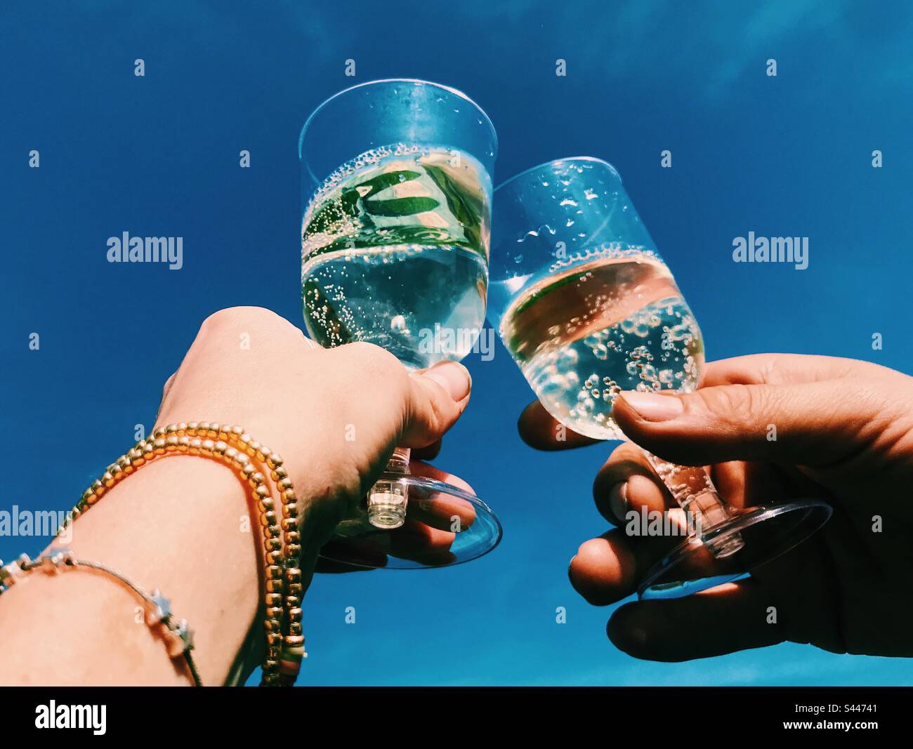 Cheers with Prosecco against a blue sky - Smartphone Captured Stock Image