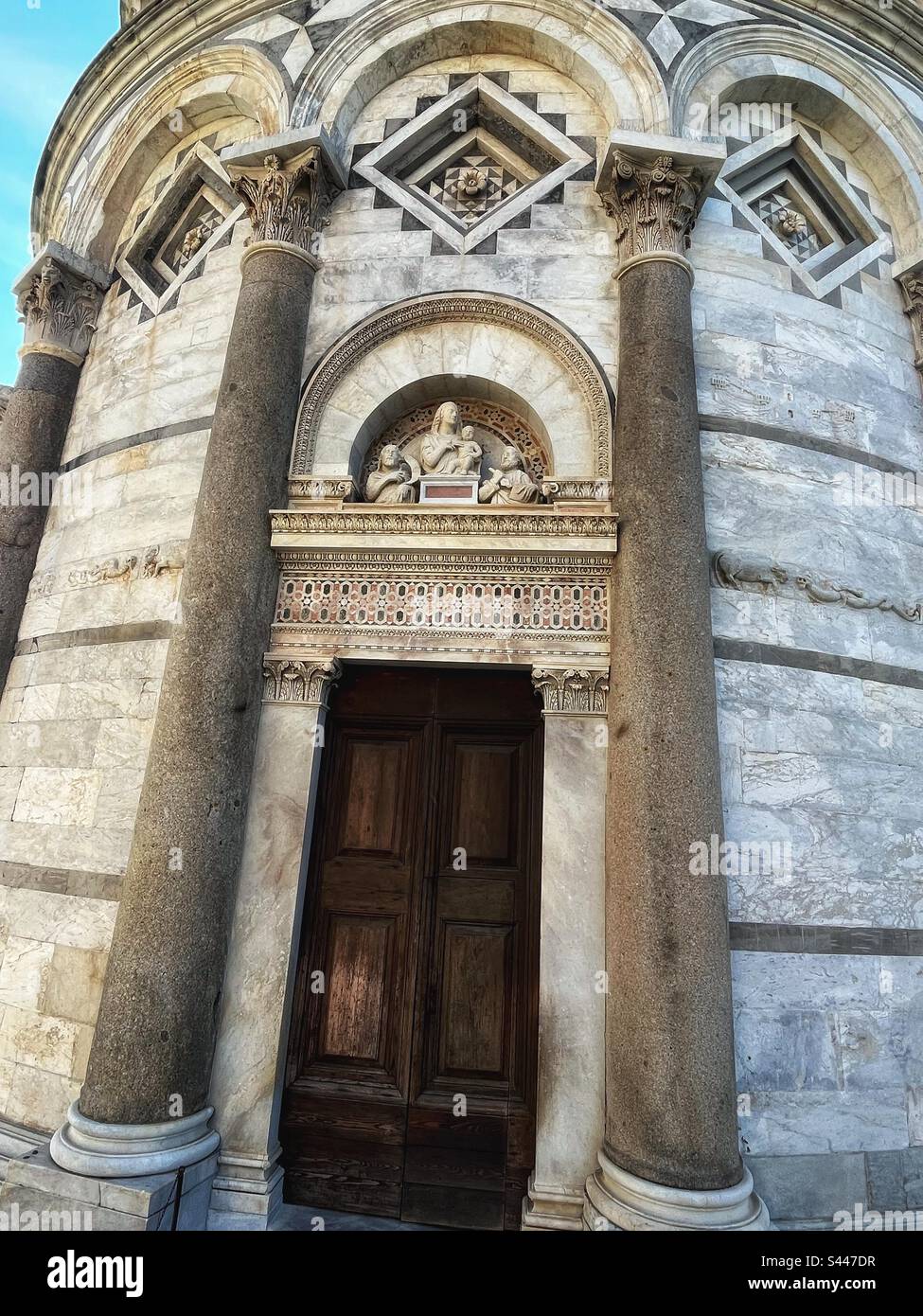 Door to the Leaning Tower of Pisa. A campanile or bell tower to the Catholic cathedral and a tourist attraction for Tuscany & Italy - Smartphone Captured Stock Image