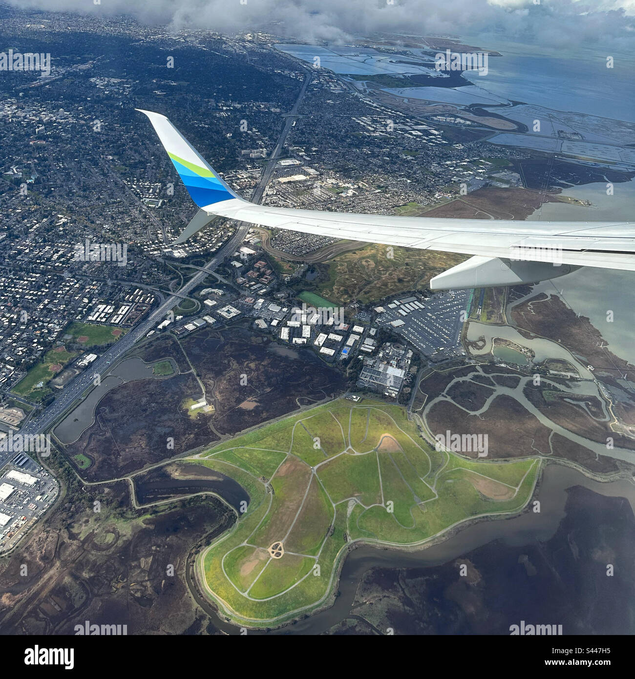 March, 2023, the wing of an Alaska Airlines airplane as it flies over Mountain View, California, United States - Smartphone Captured Stock Image