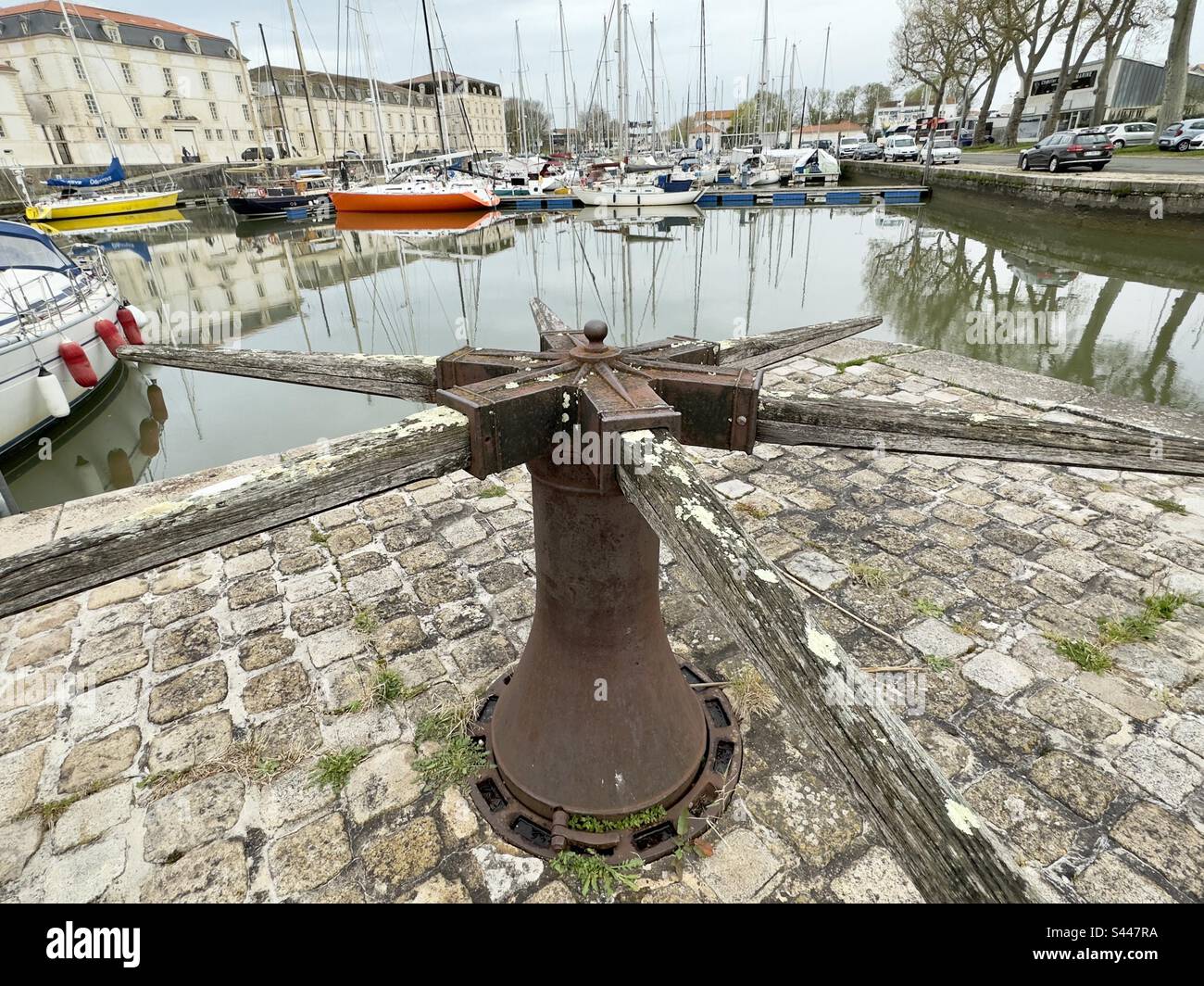 A cast iron caption with its wooden bars on the quayside of the marina in rush Rochefort, France - Smartphone Captured Stock Image